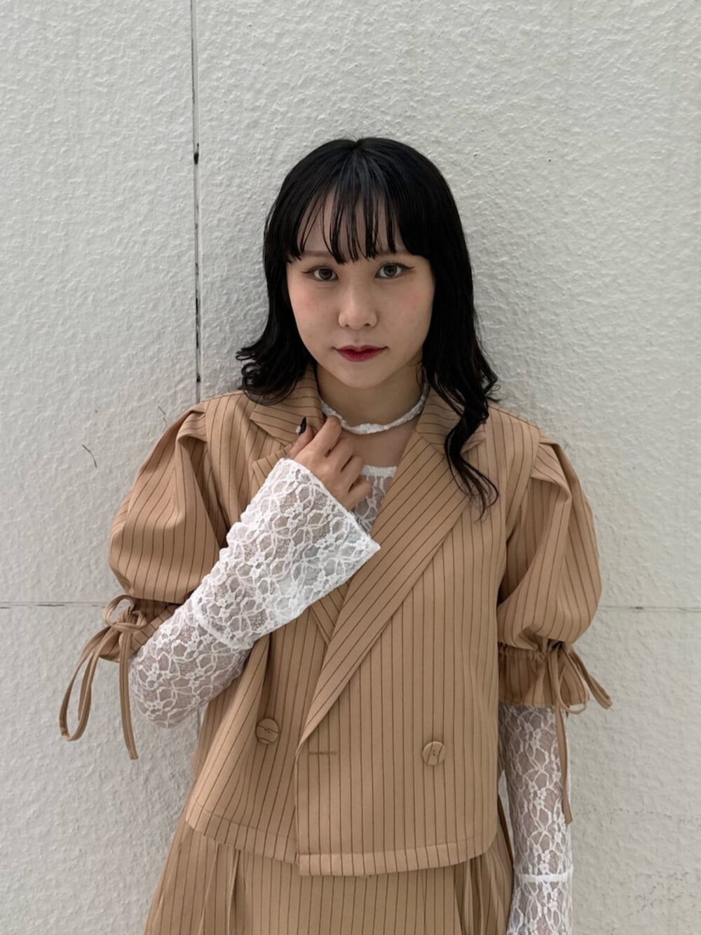 ブラック系のブーツ、ホワイト系のTシャツ/カットソー、ベージュ系のテーラードジャケットを着用したレディースの冬コーディネートの5枚目の写真