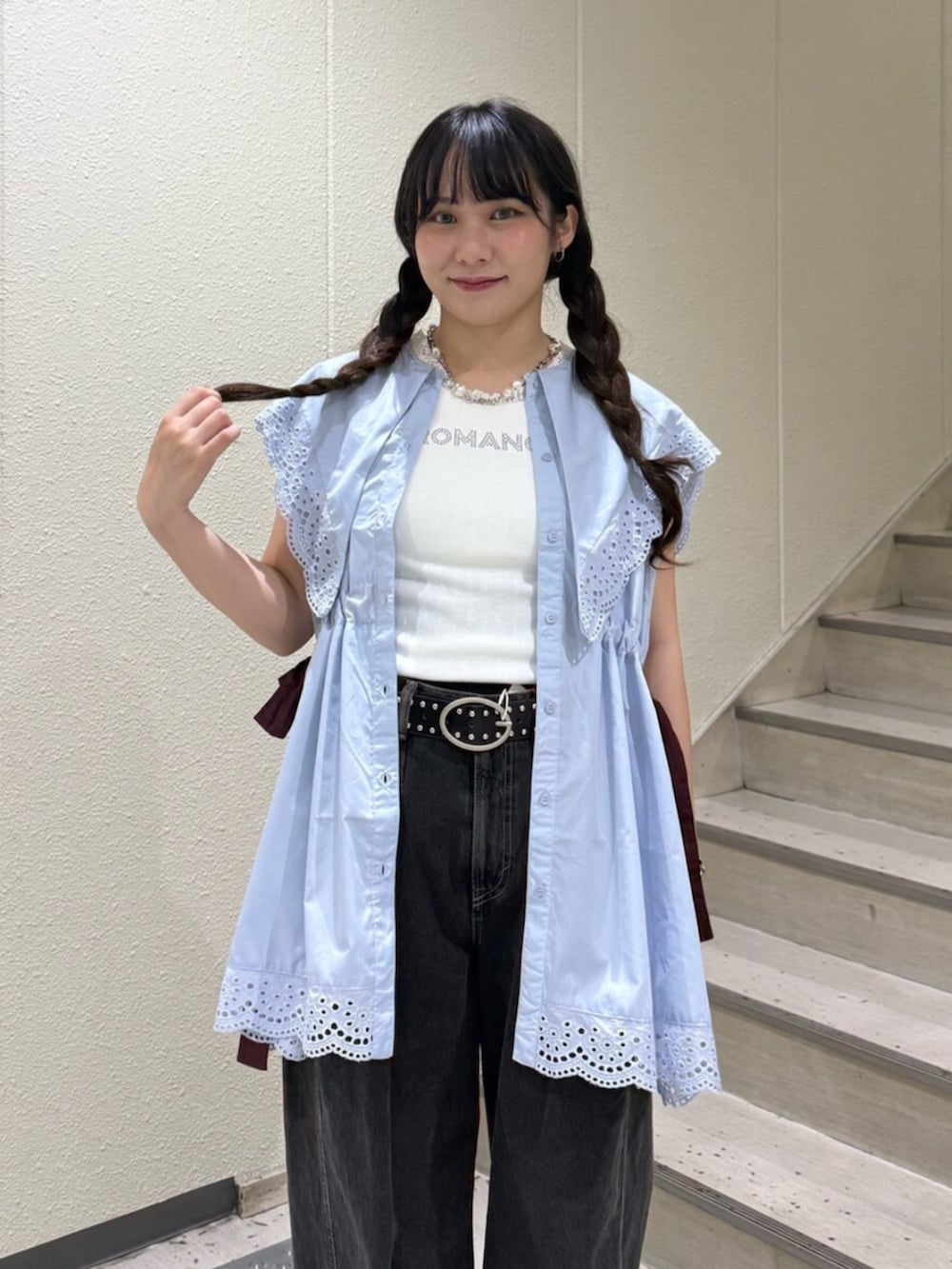 ブラック系のブーツ、ブラック系のデニムパンツ、ホワイト系のタンクトップを着用したレディースの夏コーディネートの5枚目の写真