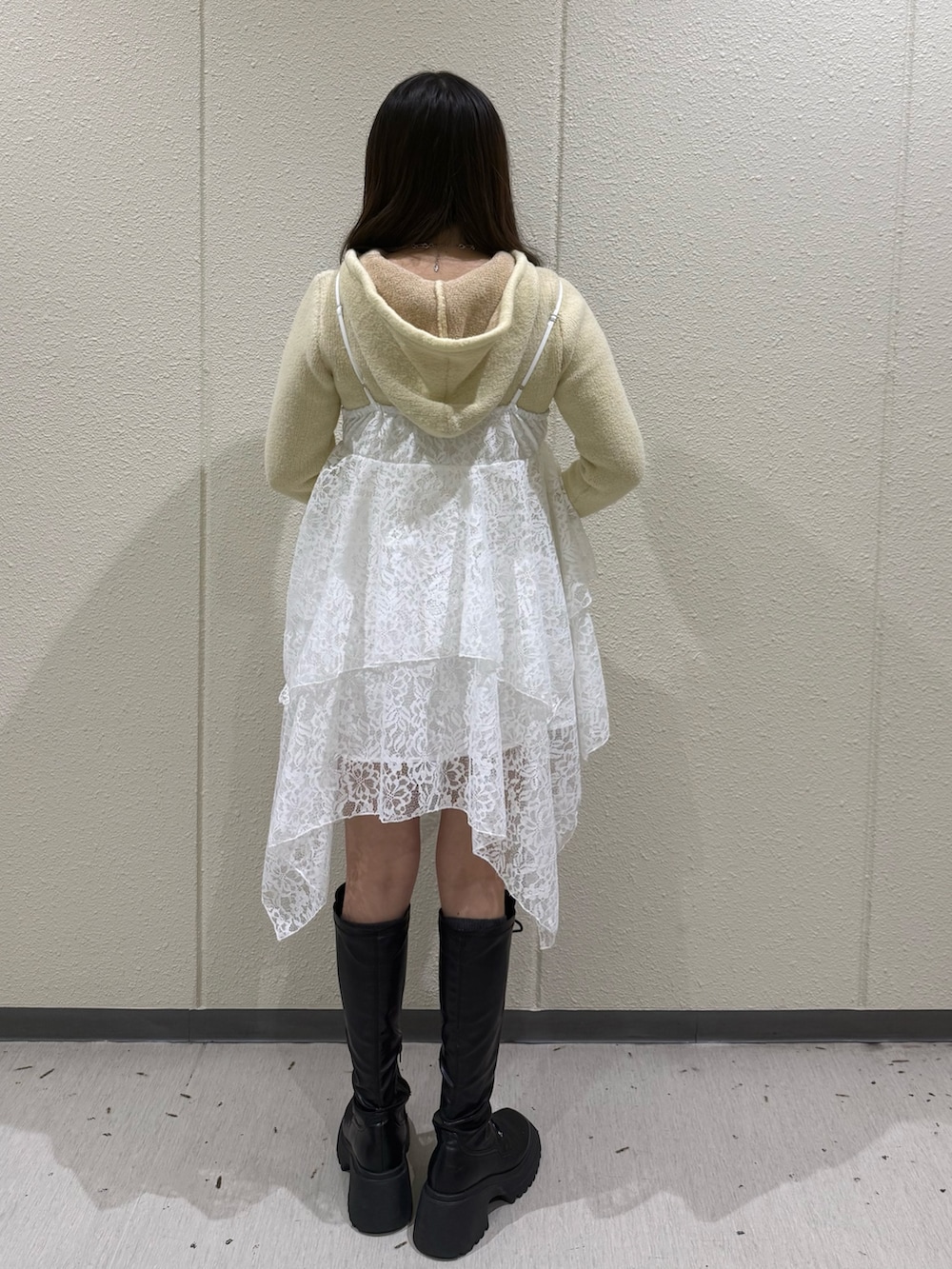 イエロー系のパーカー、ホワイト系のワンピース、シルバー系のハンドバッグを着用したレディースの冬コーディネートの4枚目の写真