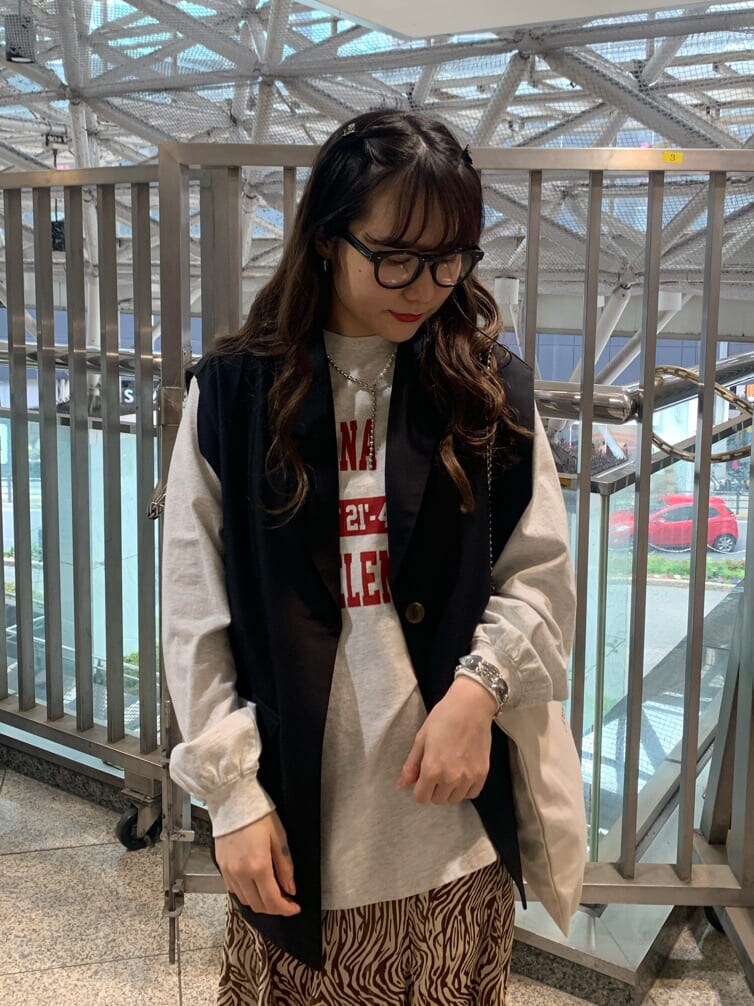 ブラック系のベスト、ホワイト系のトートバッグ、その他のスカートを着用したレディースの春コーディネートの4枚目の写真