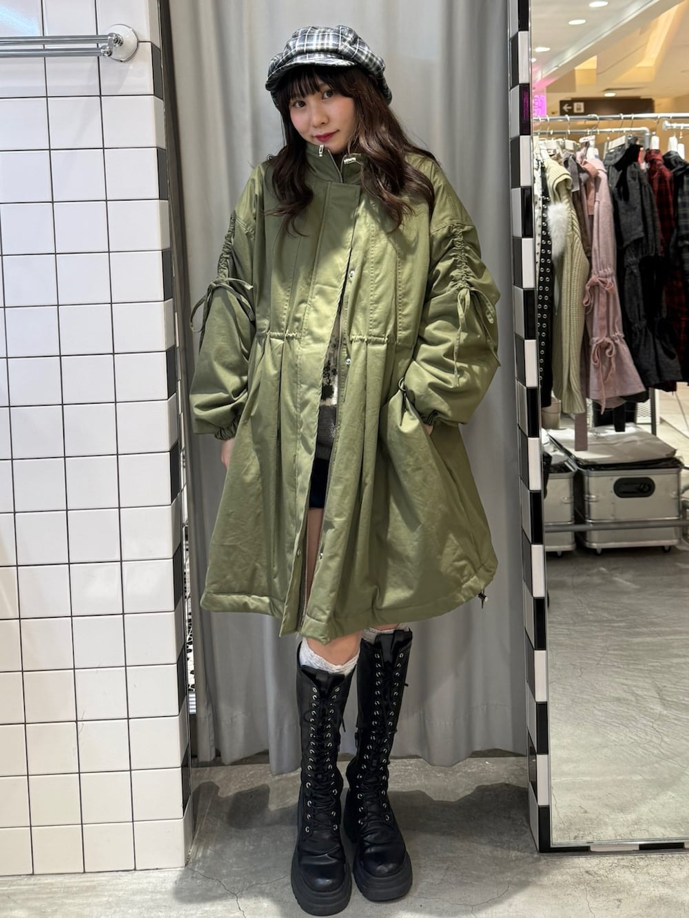 グリーン系のモッズコート、グレー系のニット/セーター、ブルー系のスカートを着用したレディースの冬コーディネートの2枚目の写真