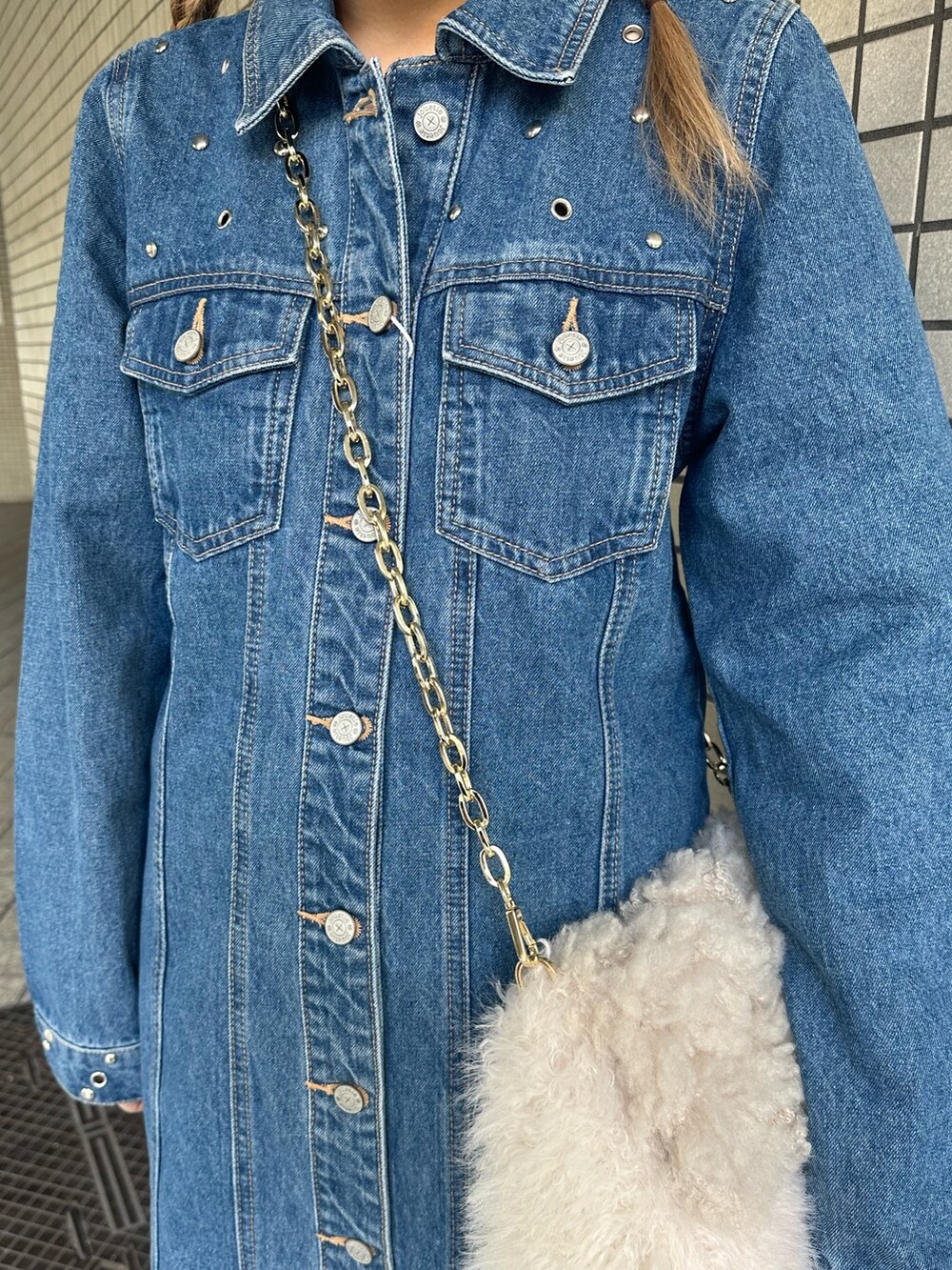 ブルー系のワンピース、ホワイト系のハンドバッグ、ブラック系のブーツを着用したレディースの冬コーディネートの6枚目の写真