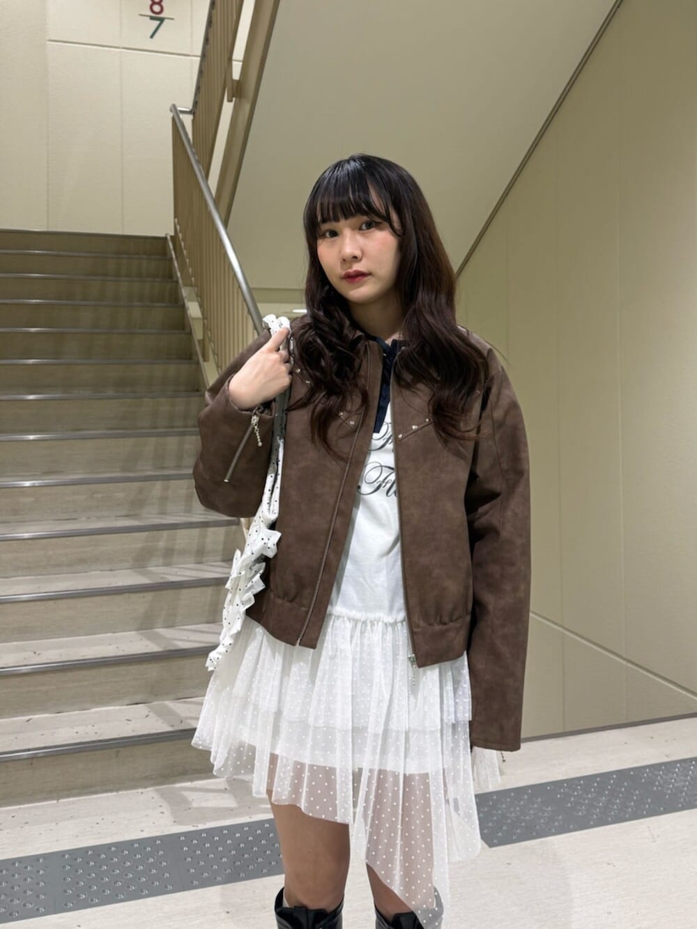 ブラック系のブーツ、ブラウン系のブルゾン、ホワイト系のワンピースを着用したレディースの冬コーディネートの8枚目の写真