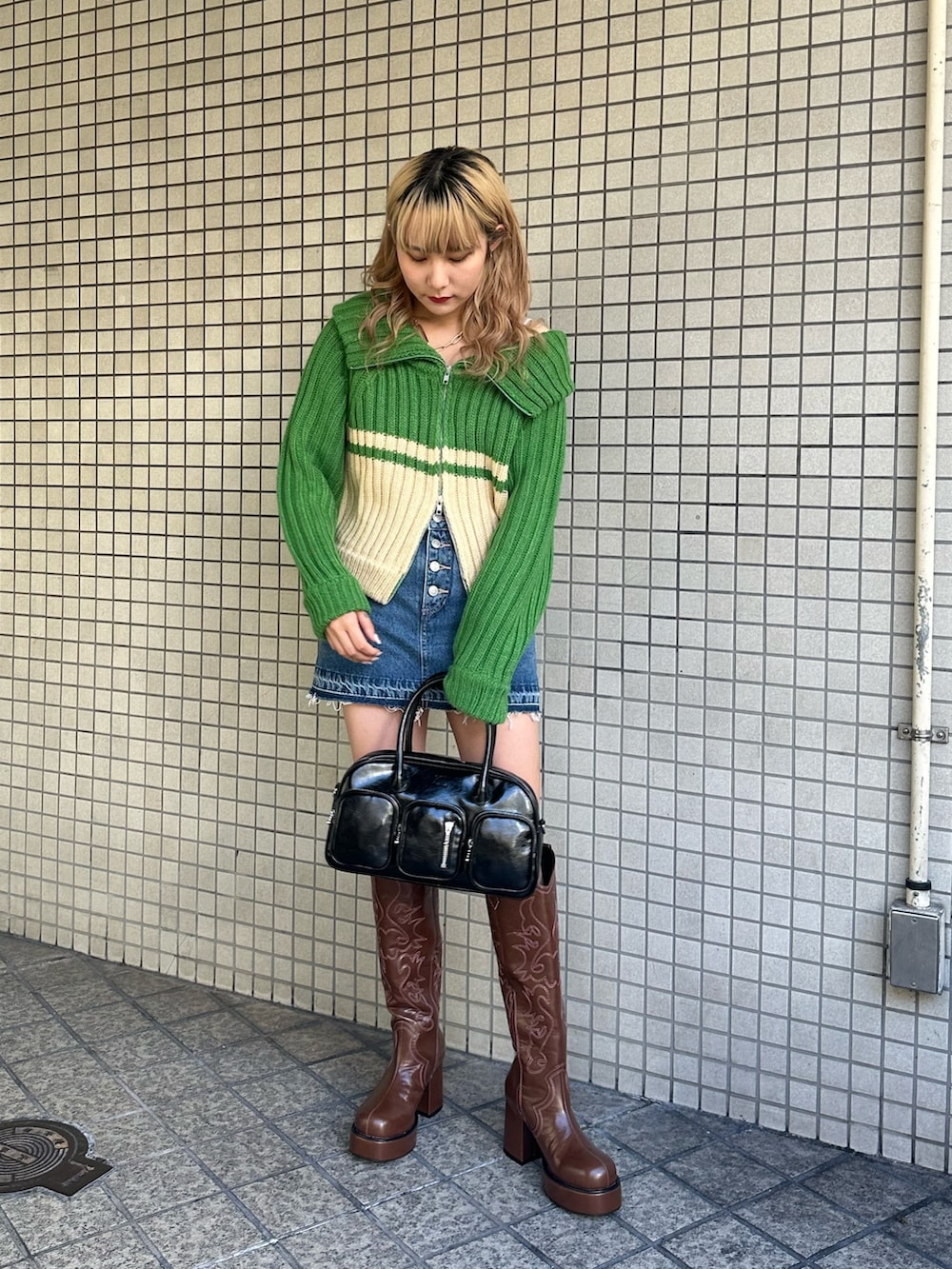 グリーン系のニット/セーター、ブルー系のデニムパンツ、ブラウン系のブーツを着用したレディースの秋コーディネートの3枚目の写真