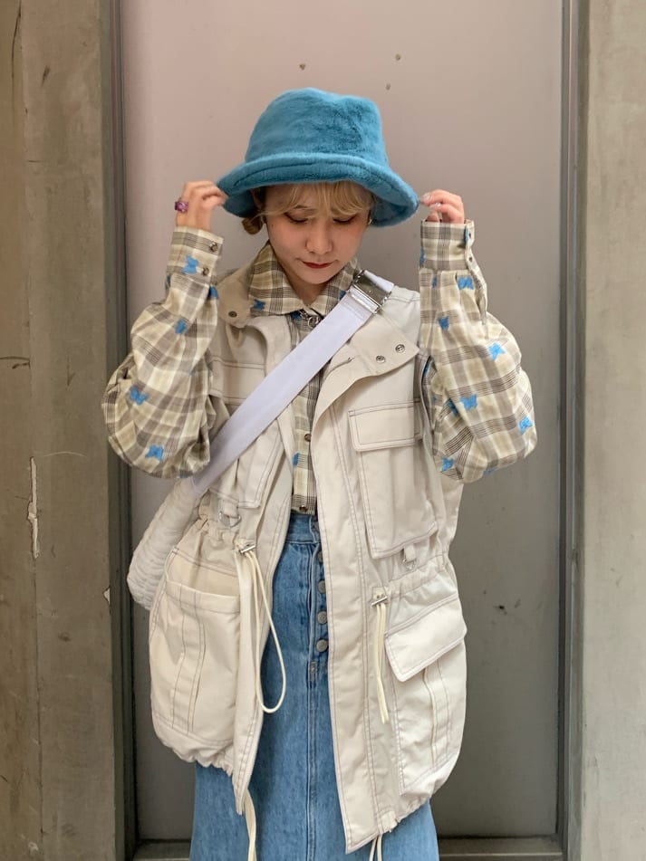 ブルー系のデニムスカート、ベージュ系のシャツ/ブラウス、ホワイト系のベストを着用したレディースの秋コーディネートの3枚目の写真