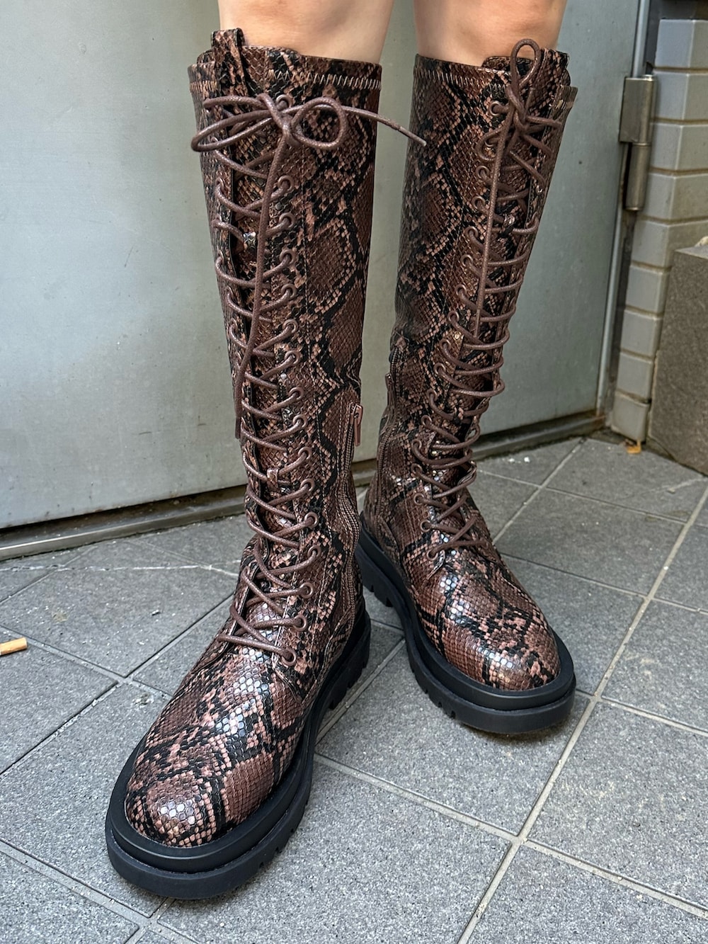 レッド系のニット/セーター、ホワイト系のTシャツ/カットソー、グリーン系のスカートを着用したレディースの秋コーディネートの6枚目の写真