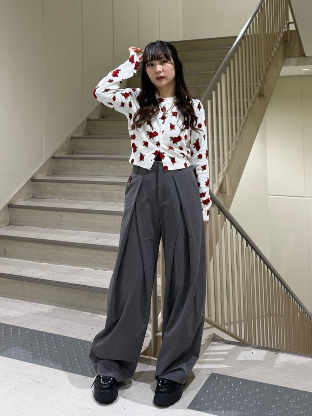 グレー系のスラックス、ホワイト系のカーディガン/ボレロ、ブラック系のローファーを着用したレディースの冬コーディネートの7枚目の写真