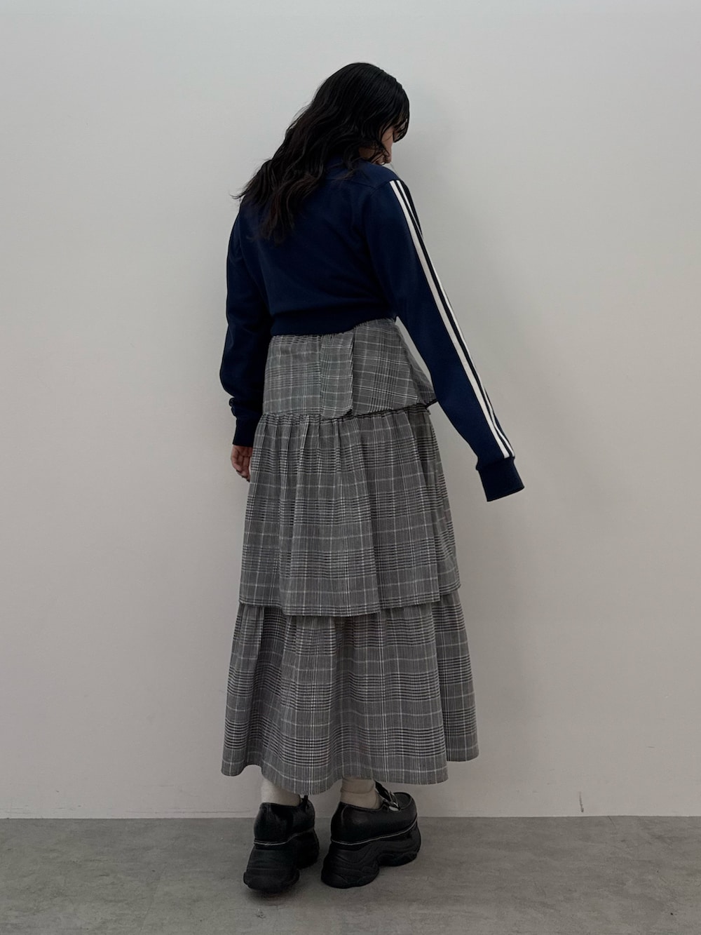 ブルー系のジャージ、グレー系のスカート、ブラック系のスニーカーを着用したレディースの春コーディネートの3枚目の写真