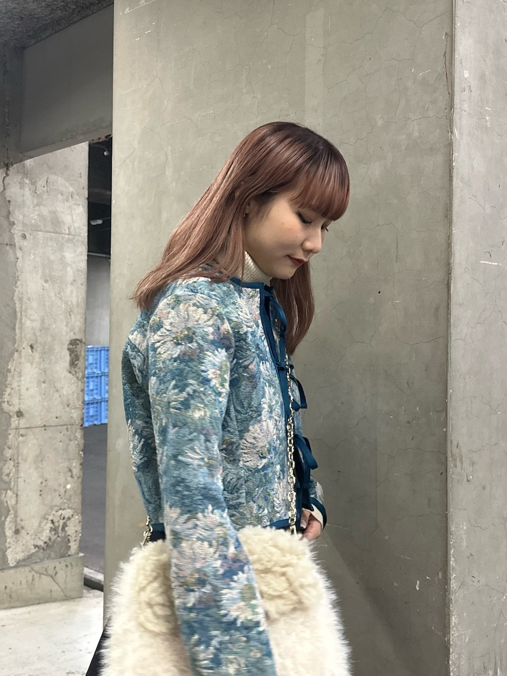 ブラック系のスカート、ブルー系のノーカラージャケット、ホワイト系のハンドバッグを着用したレディースの冬コーディネートの5枚目の写真