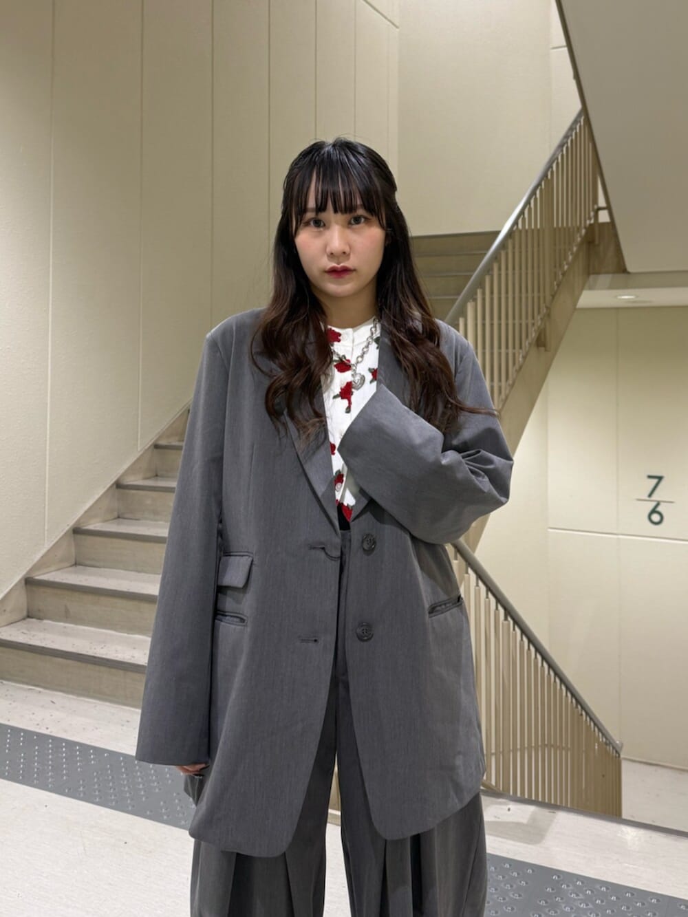 グレー系のスラックス、グレー系のテーラードジャケット、ホワイト系のカーディガン/ボレロを着用したレディースの冬コーディネートの8枚目の写真