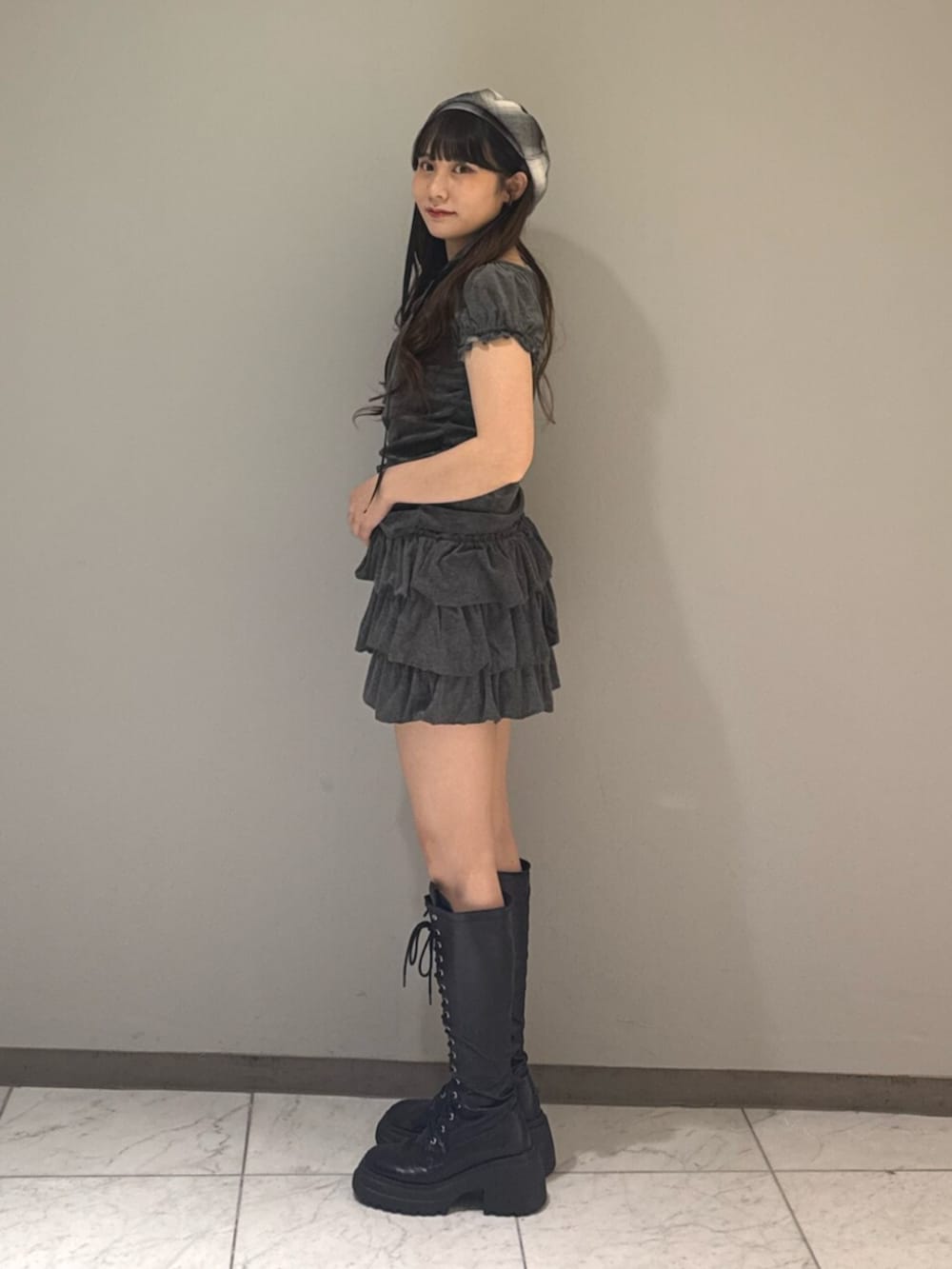 ブラック系のブーツ、グレー系のTシャツ/カットソー、グレー系のスカートを着用したレディースの夏コーディネートの2枚目の写真
