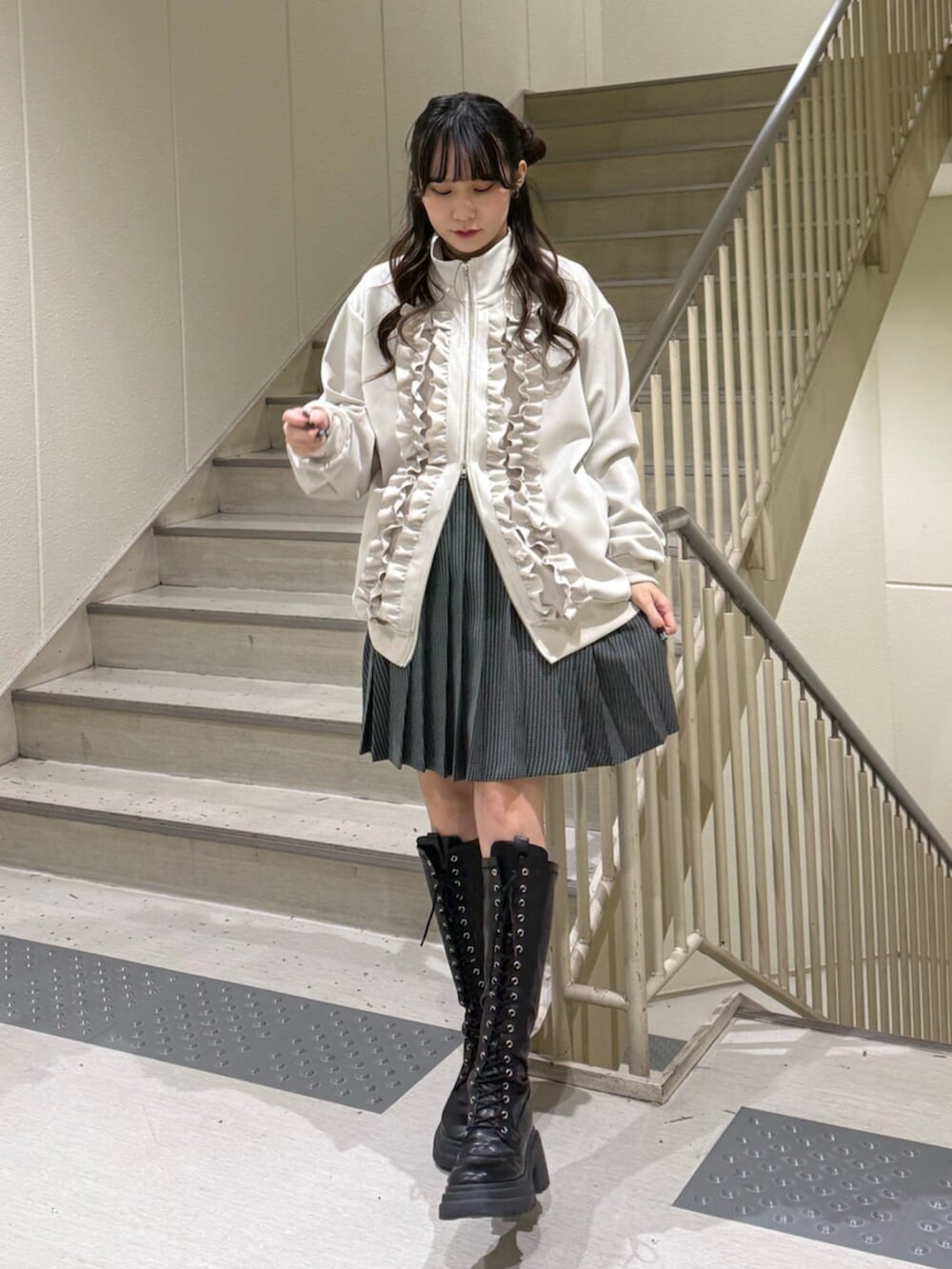 ブラック系のブーツ、ホワイト系のジャージ、その他のスカートを着用したレディースの冬コーディネートの2枚目の写真