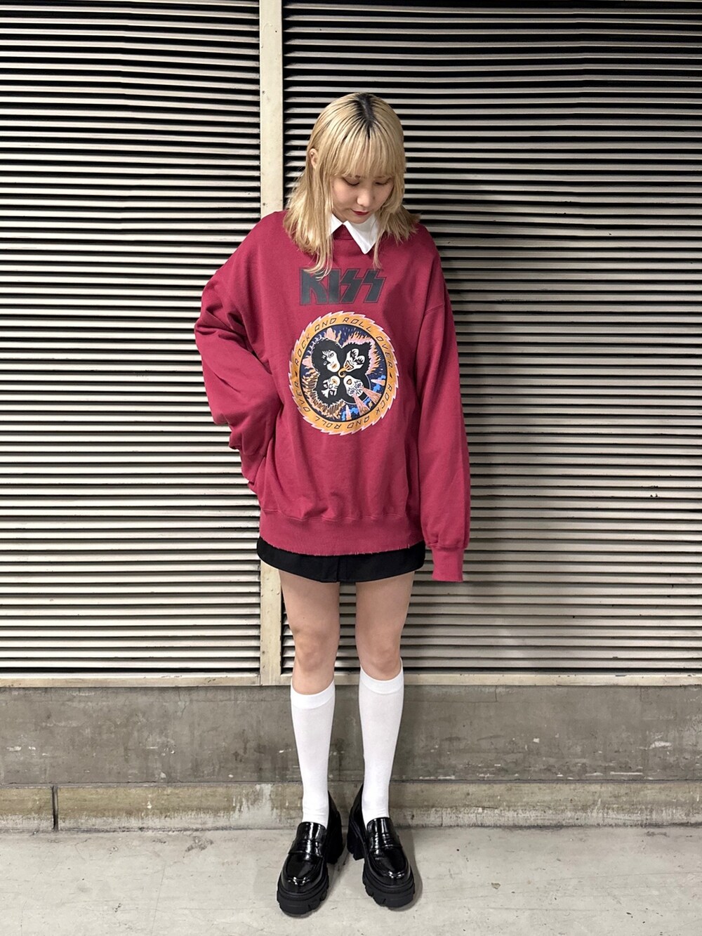 ブラック系のワンピース、ブラック系のローファー、レッド系のスウェットを着用したレディースの冬コーディネートの2枚目の写真