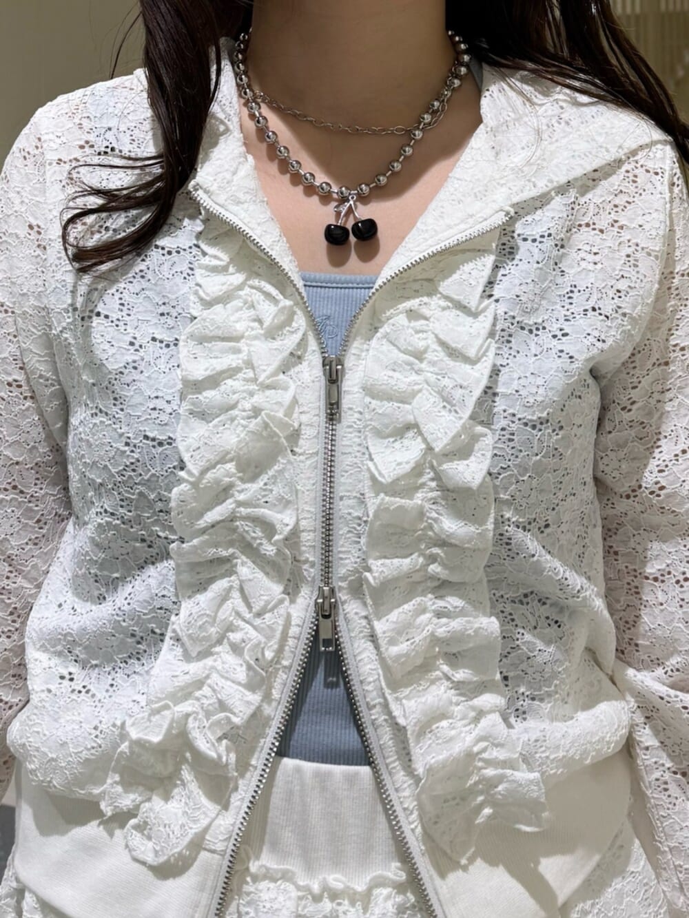 ブラック系のブーツ、ブルー系のキャミソール、ホワイト系のパーカーを着用したレディースの春コーディネートの10枚目の写真