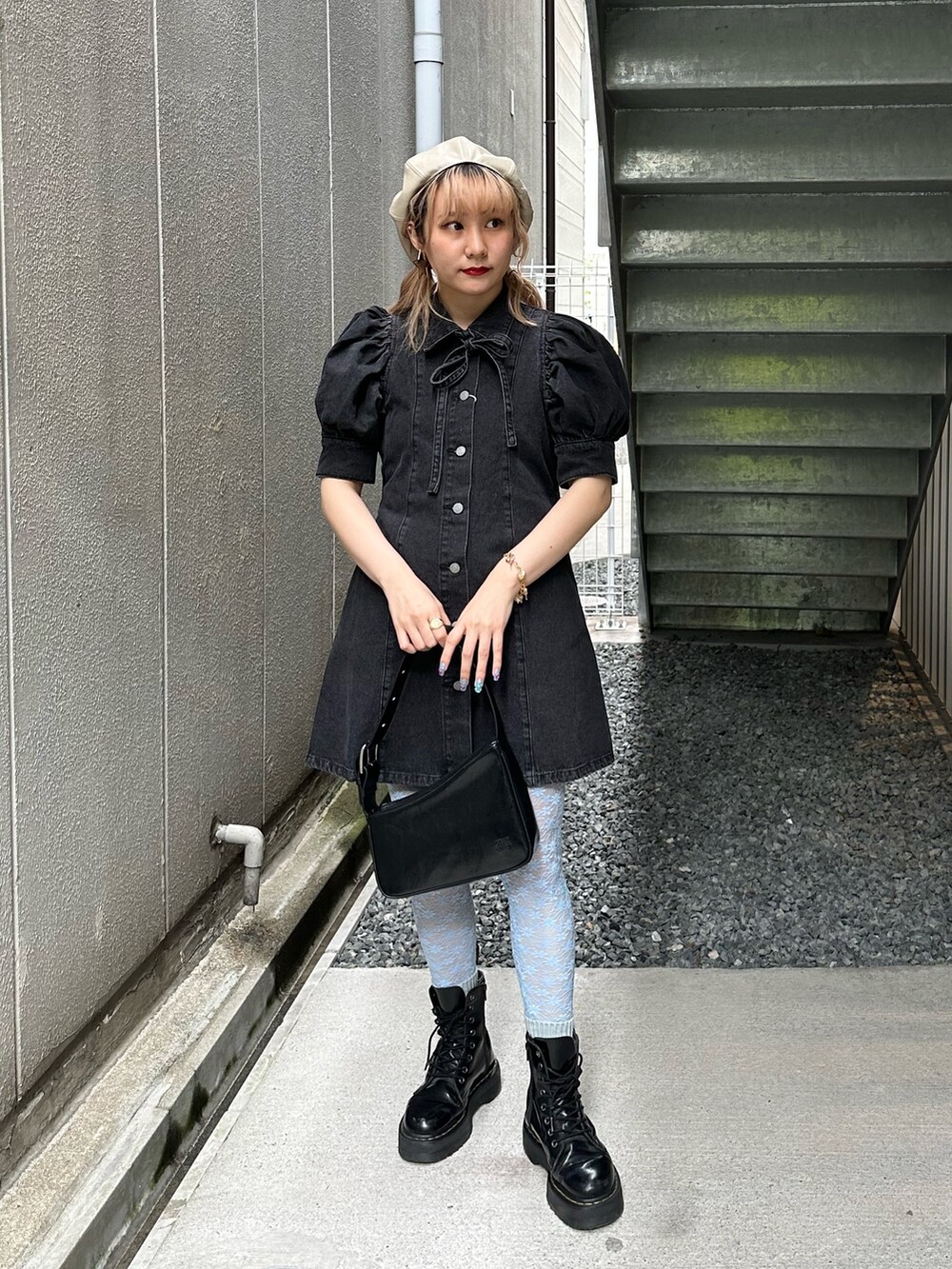 ブラック系のワンピース、ブラック系のハンドバッグ、ゴールド系のピアス（両耳用）を着用したレディースの春コーディネートの2枚目の写真