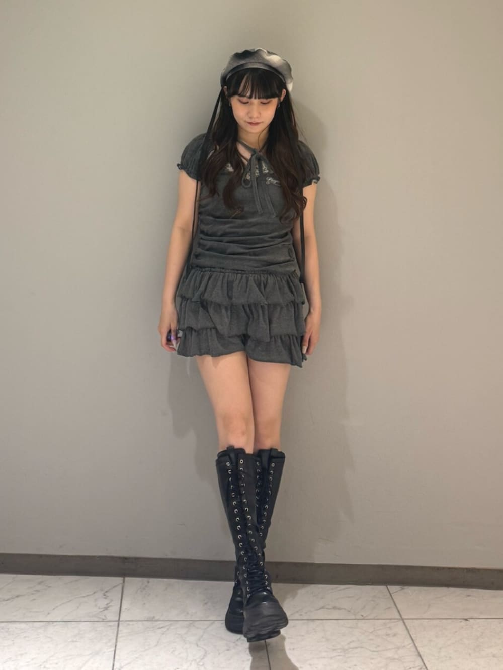 ブラック系のブーツ、グレー系のTシャツ/カットソー、グレー系のスカートを着用したレディースの夏コーディネートの4枚目の写真