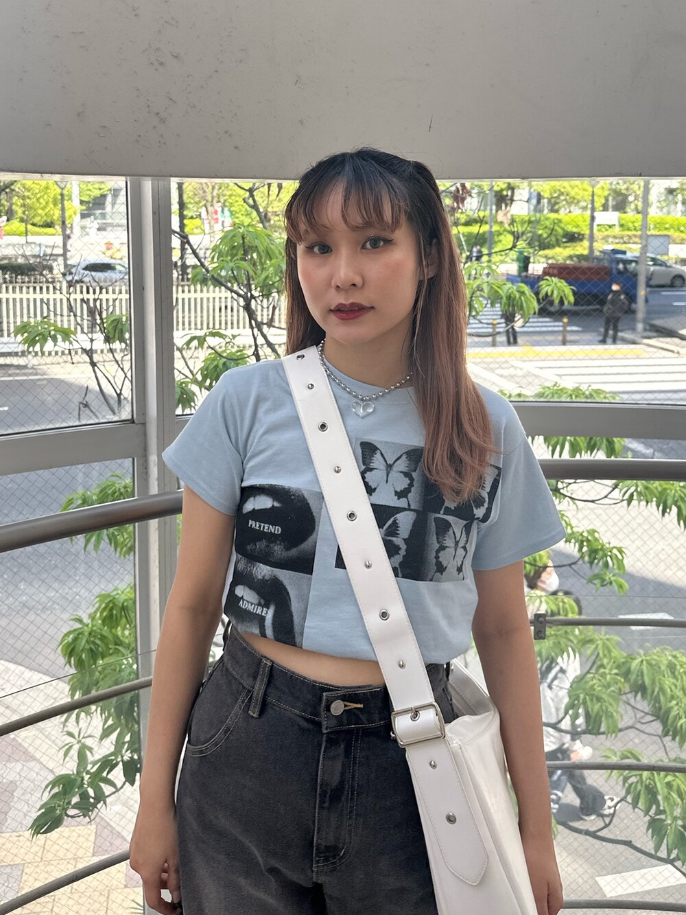 ブラック系のデニムパンツ、ホワイト系のショルダーバッグ、ブルー系のTシャツ/カットソーを着用したレディースの春コーディネートの4枚目の写真