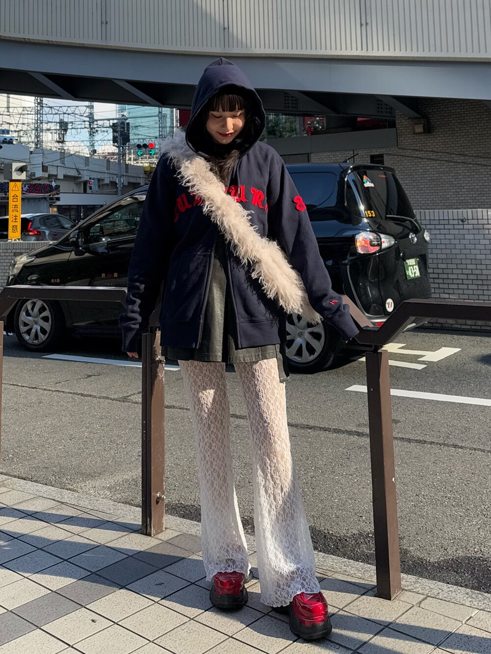 ブルー系のパーカー、ホワイト系のショルダーバッグ、ブラック系のスカートを着用したレディースの冬コーディネートの4枚目の写真