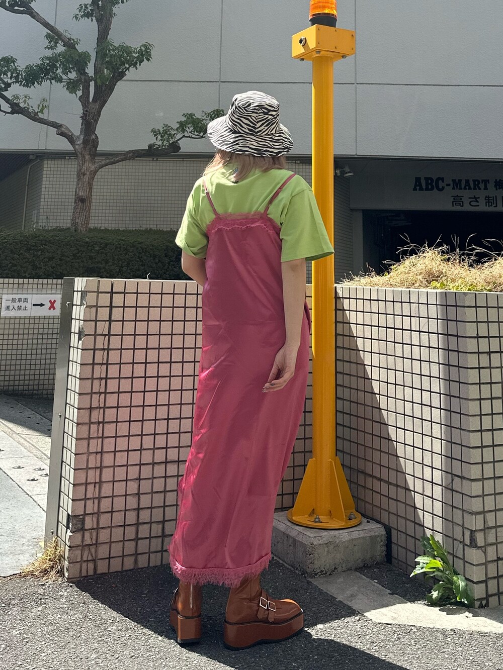 グリーン系のTシャツ/カットソー、ブルー系のデニムパンツ、ピンク系のワンピースを着用したレディースの春コーディネートの3枚目の写真