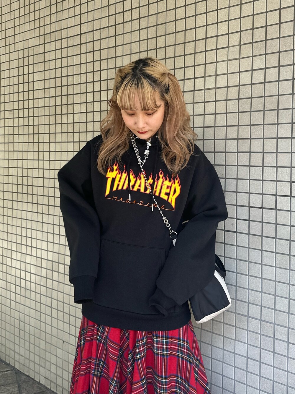 レッド系のスカート、ブラック系のパーカー、ブラック系のハンドバッグを着用したレディースの秋コーディネートの4枚目の写真