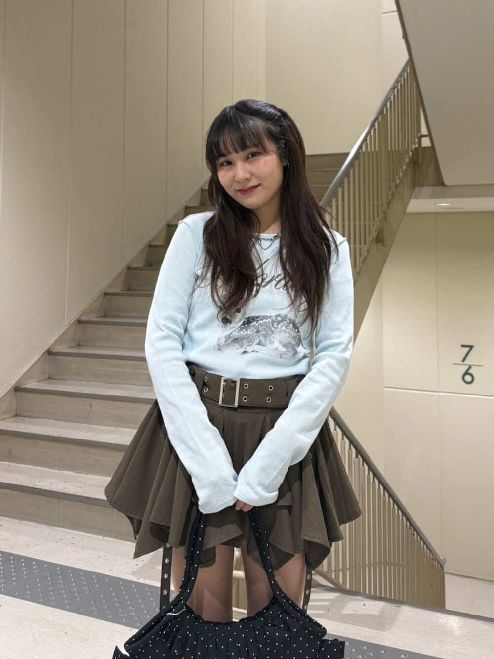 ベージュ系のスカート、ブルー系のTシャツ/カットソー、ブラック系のトートバッグを着用したレディースの春コーディネートの8枚目の写真