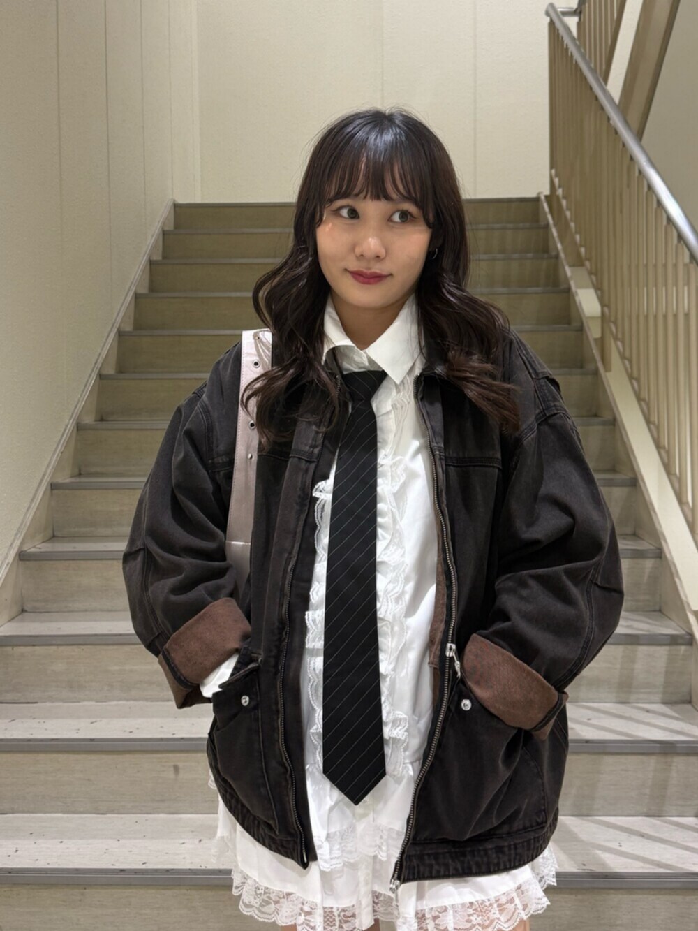 ブラック系のデニムジャケット、ブラック系のブーツ、ホワイト系のシャツ/ブラウスを着用したレディースの秋コーディネートの8枚目の写真