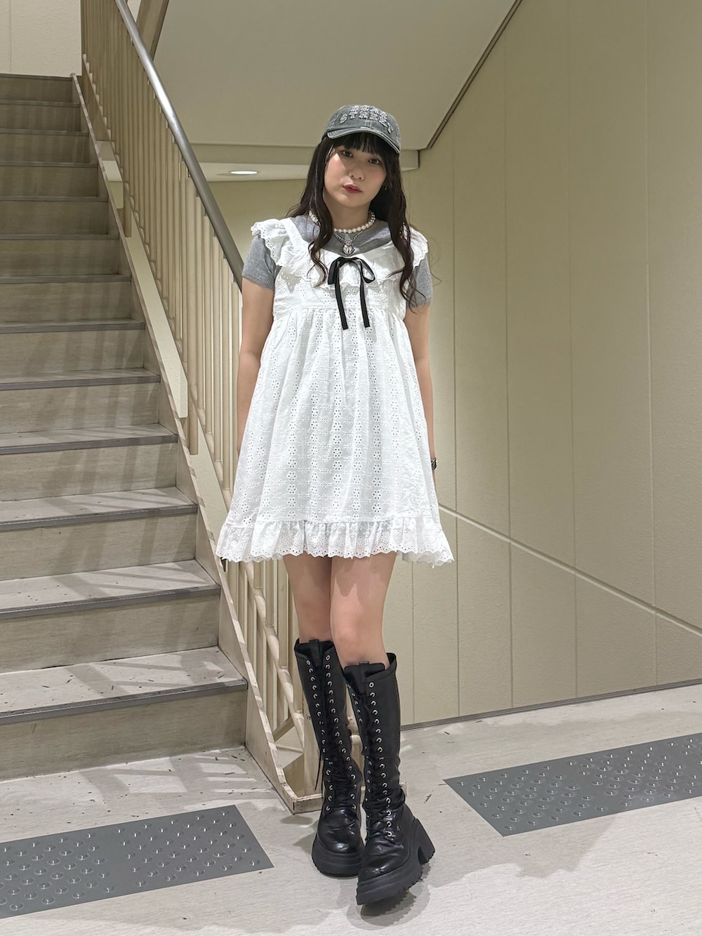 ホワイト系のワンピース、グレー系のTシャツ/カットソー、ブラック系のブーツを着用したレディースの春コーディネートの5枚目の写真