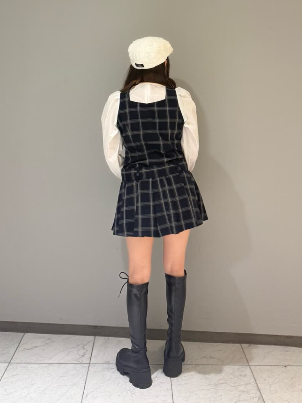 ブラック系のブーツ、ブルー系のワンピース、ホワイト系のハンチング/ベレー帽を着用したレディースの夏コーディネートの3枚目の写真
