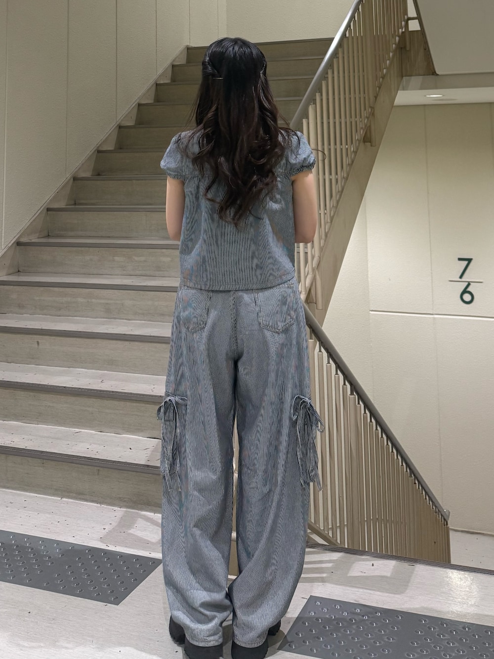 ブラック系のデニムパンツ、ブラック系のブーツ、ブラック系のその他トップスを着用したレディースの春コーディネートの5枚目の写真