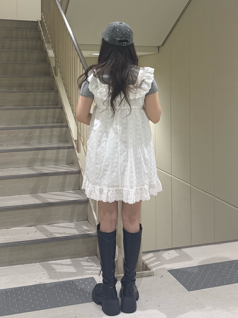 ホワイト系のワンピース、グレー系のTシャツ/カットソー、ブラック系のブーツを着用したレディースの春コーディネートの4枚目の写真