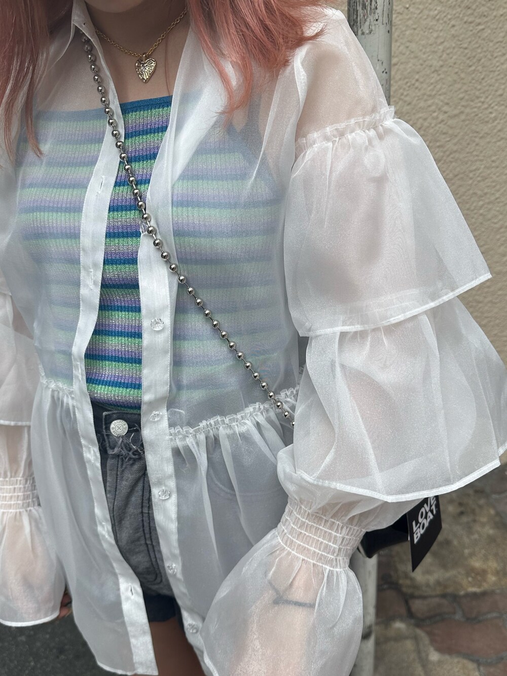 ブラック系のブーツ、ブラック系のデニムパンツ、ホワイト系のシャツ/ブラウスを着用したレディースの夏コーディネートの5枚目の写真