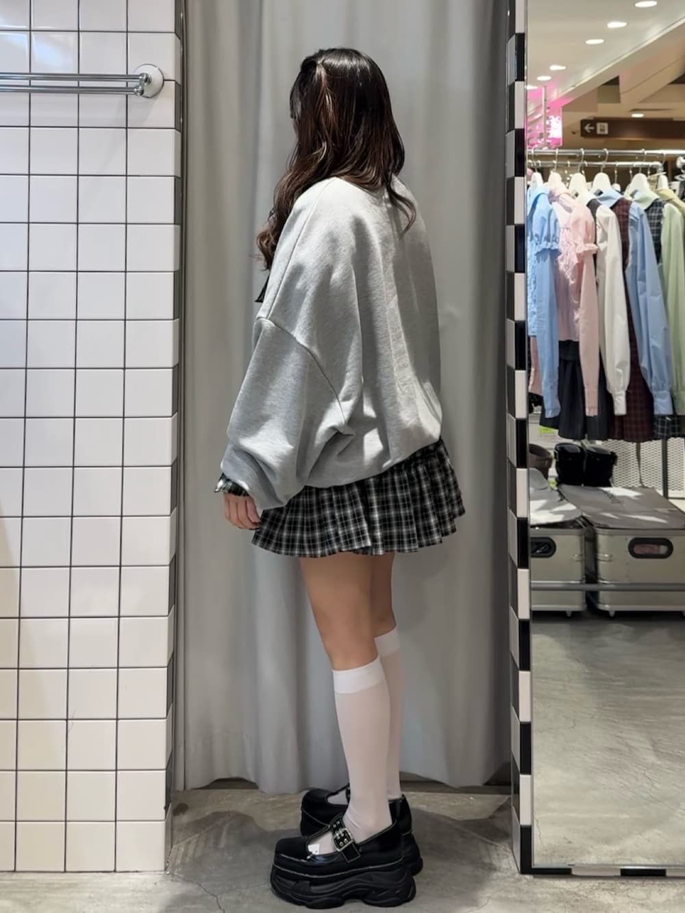 ブラック系のワンピース、グレー系のスウェット、ブラック系のローファーを着用したレディースの冬コーディネートの3枚目の写真