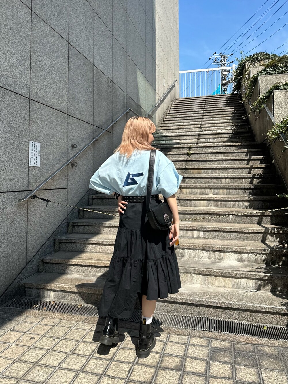 ブルー系のTシャツ/カットソー、ブラック系のショルダーバッグ、ブラック系のスカートを着用したレディースの春コーディネートの4枚目の写真