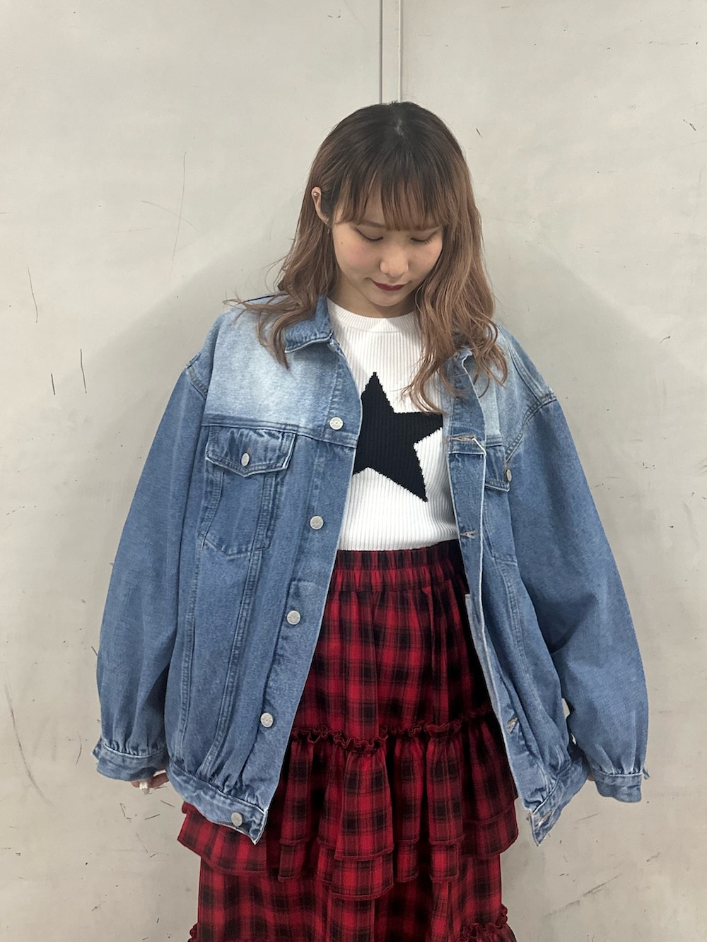 ブルー系のデニムジャケット、ホワイト系のニット/セーター、レッド系のスカートを着用したレディースの春コーディネートの5枚目の写真