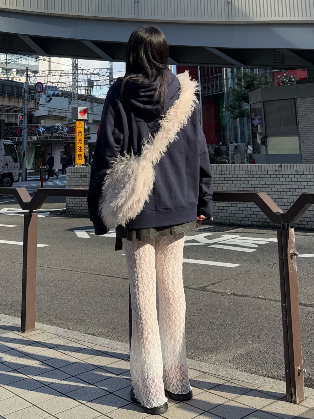 ブルー系のパーカー、ホワイト系のショルダーバッグ、ブラック系のスカートを着用したレディースの冬コーディネートの3枚目の写真