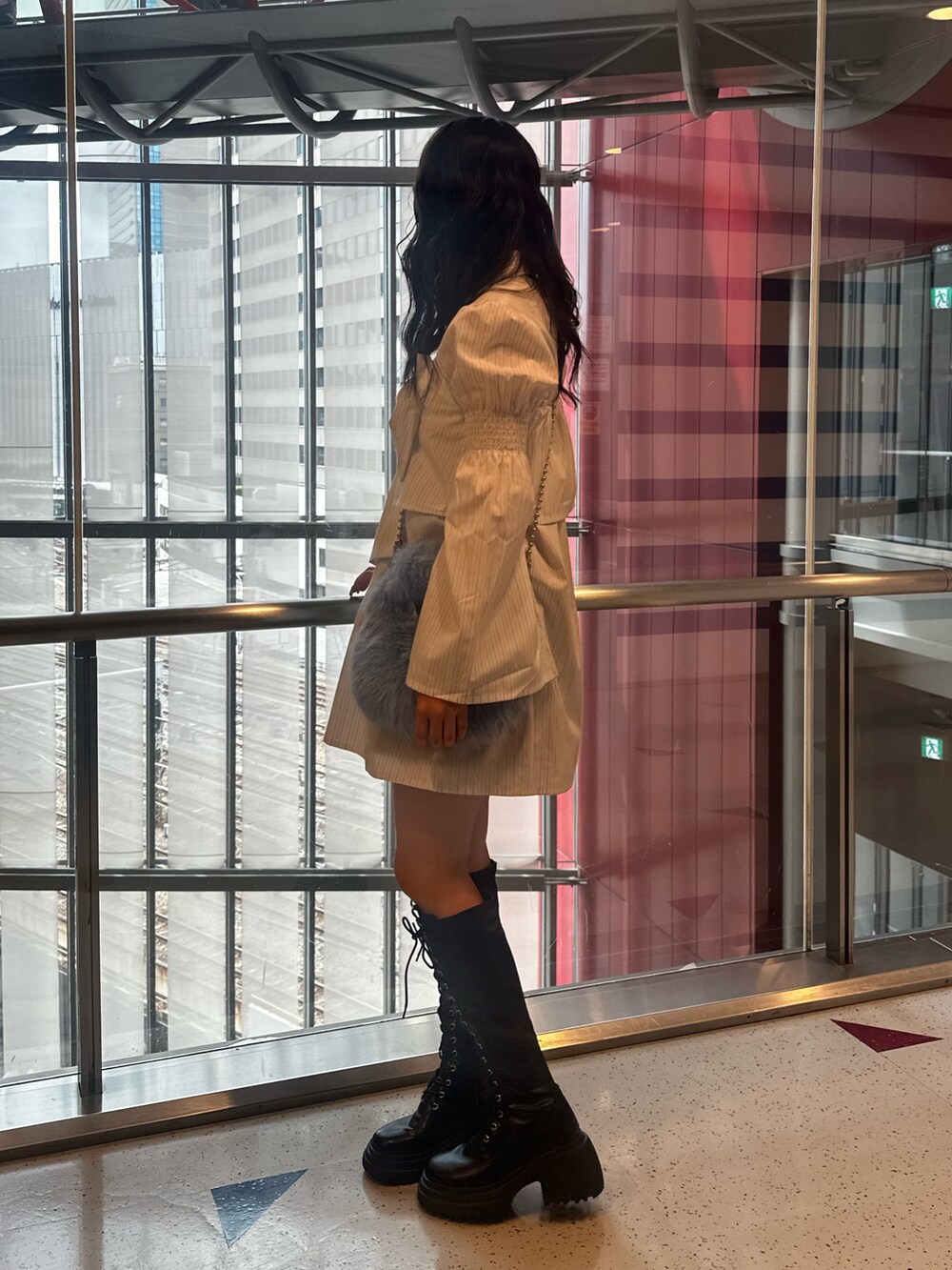 ホワイト系のシャツワンピース、ブルー系のハンドバッグ、ブラック系のブーツを着用したレディースの夏コーディネートの3枚目の写真