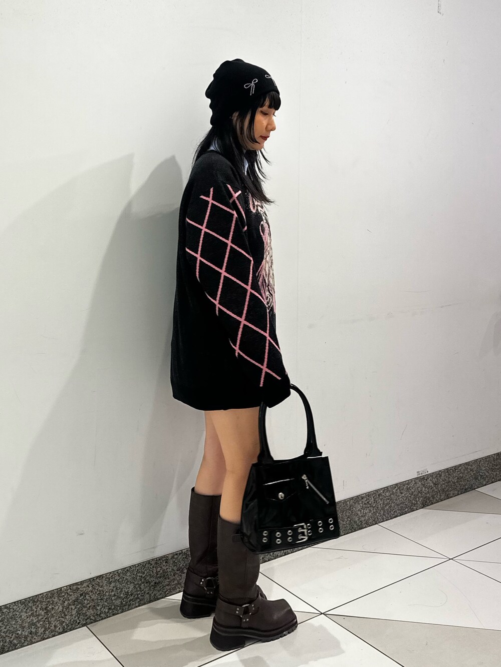 ブラック系のニット/セーター、ブラウン系のブーツ、ブルー系のシャツ/ブラウスを着用したレディースの秋コーディネートの3枚目の写真