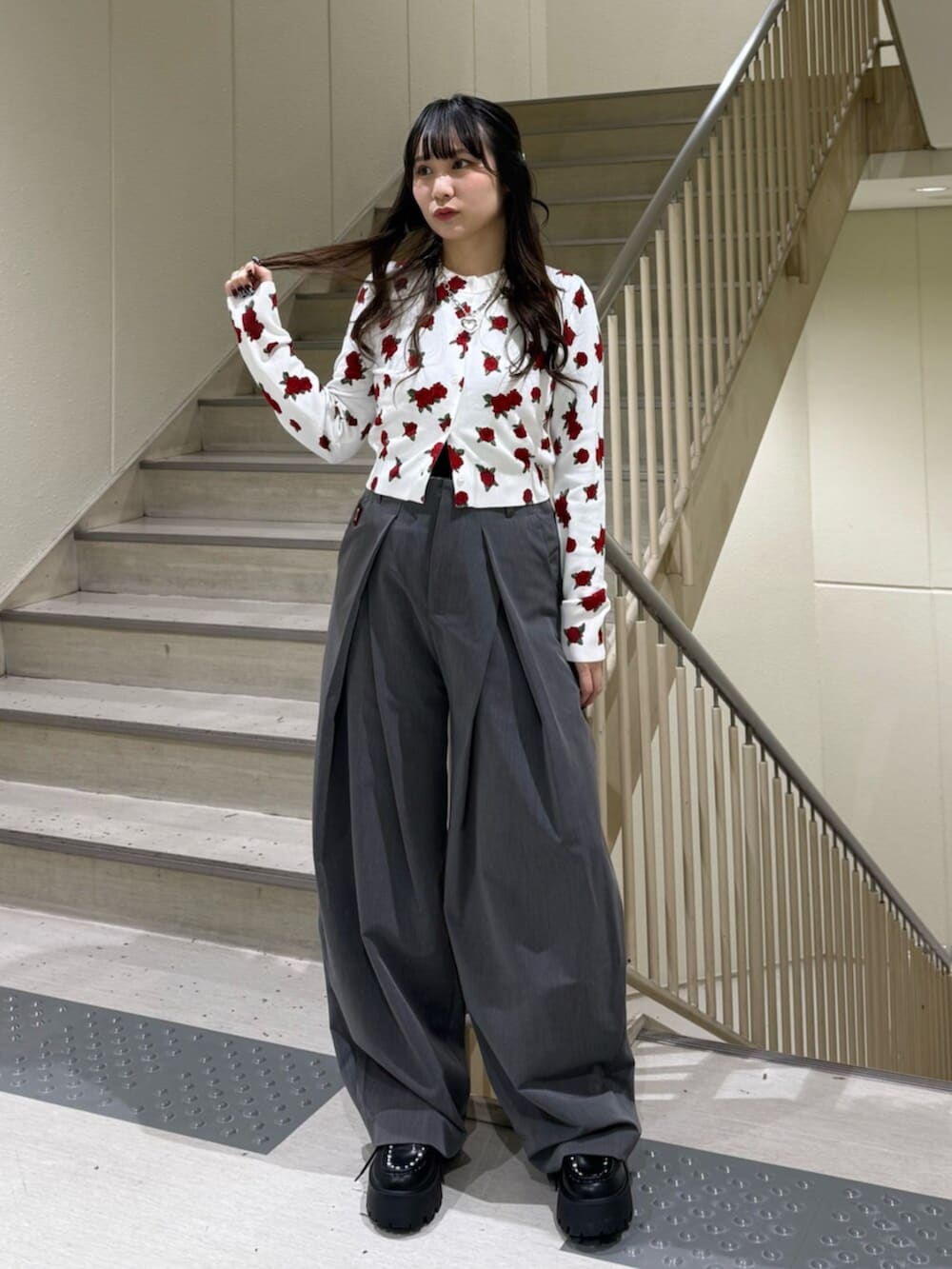 グレー系のスラックス、ホワイト系のカーディガン/ボレロ、ブラック系のローファーを着用したレディースの冬コーディネートの3枚目の写真