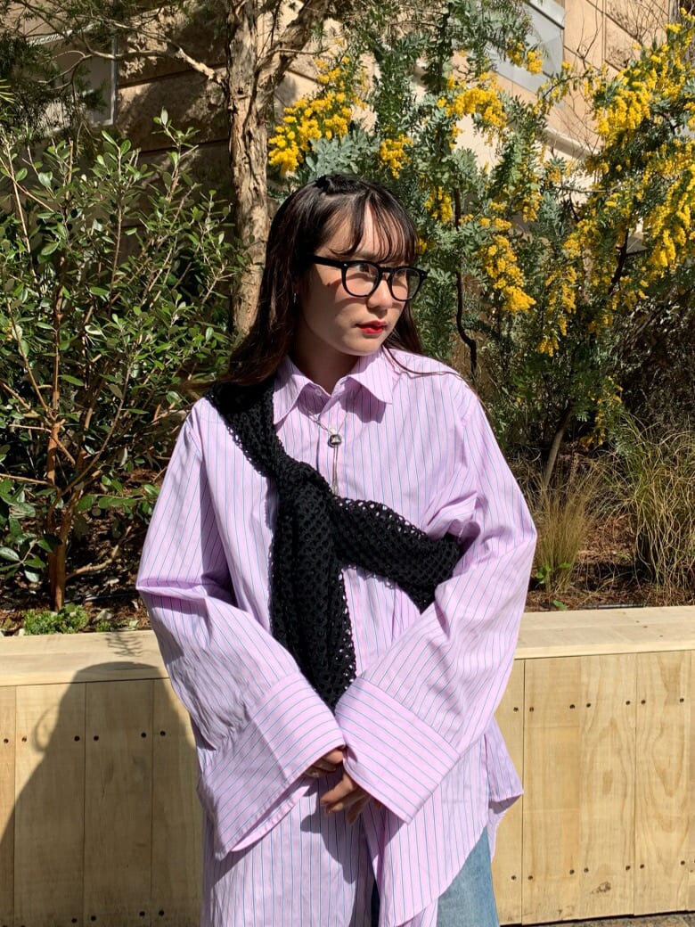 ピンク系のシャツ/ブラウス、ブラック系のTシャツ/カットソー、ブルー系のデニムパンツを着用したレディースの春コーディネートの3枚目の写真