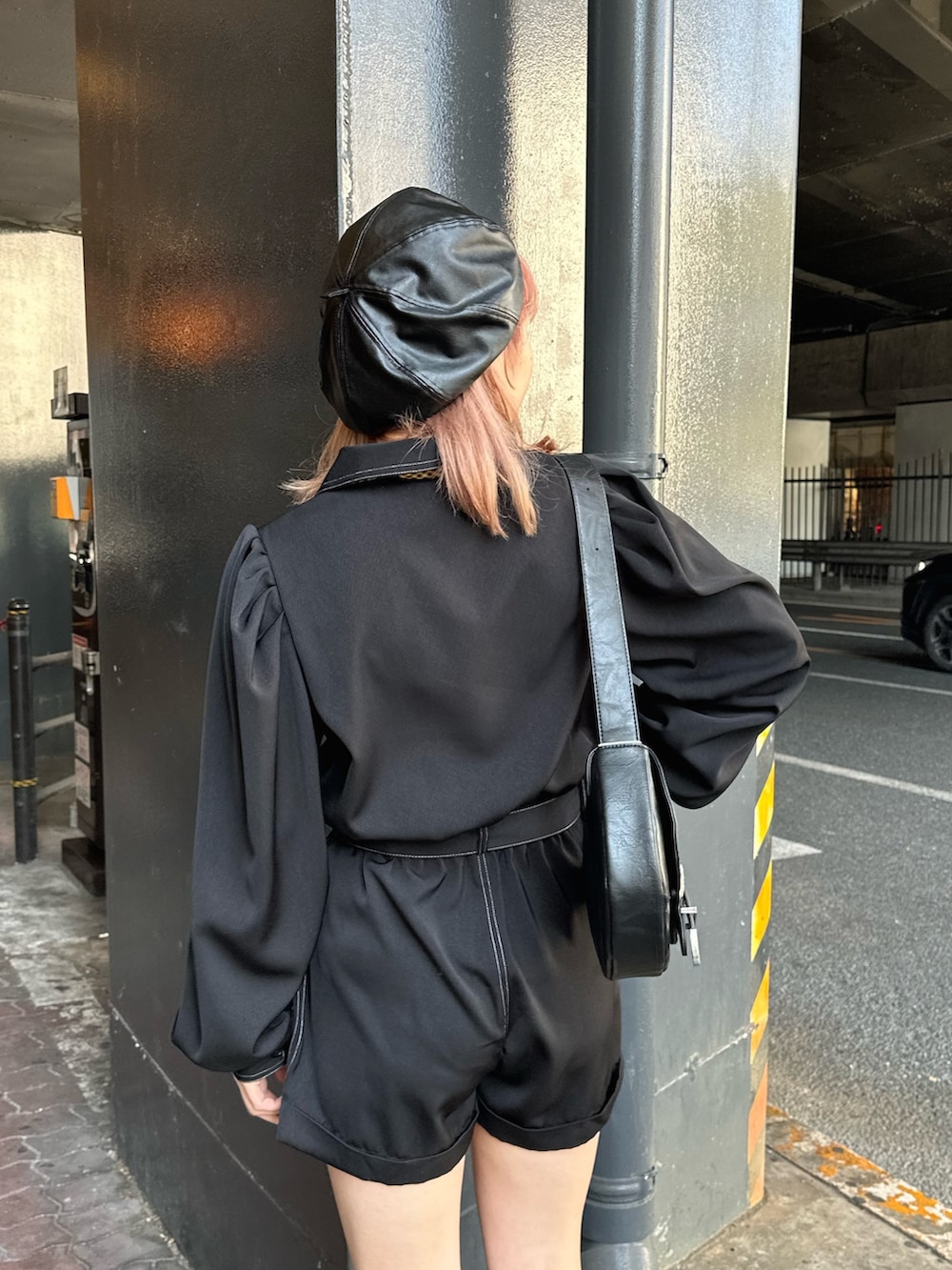 ブラック系のつなぎ/オールインワン、ブラック系のショルダーバッグ、ブラック系のブーツを着用したレディースの春コーディネートの4枚目の写真