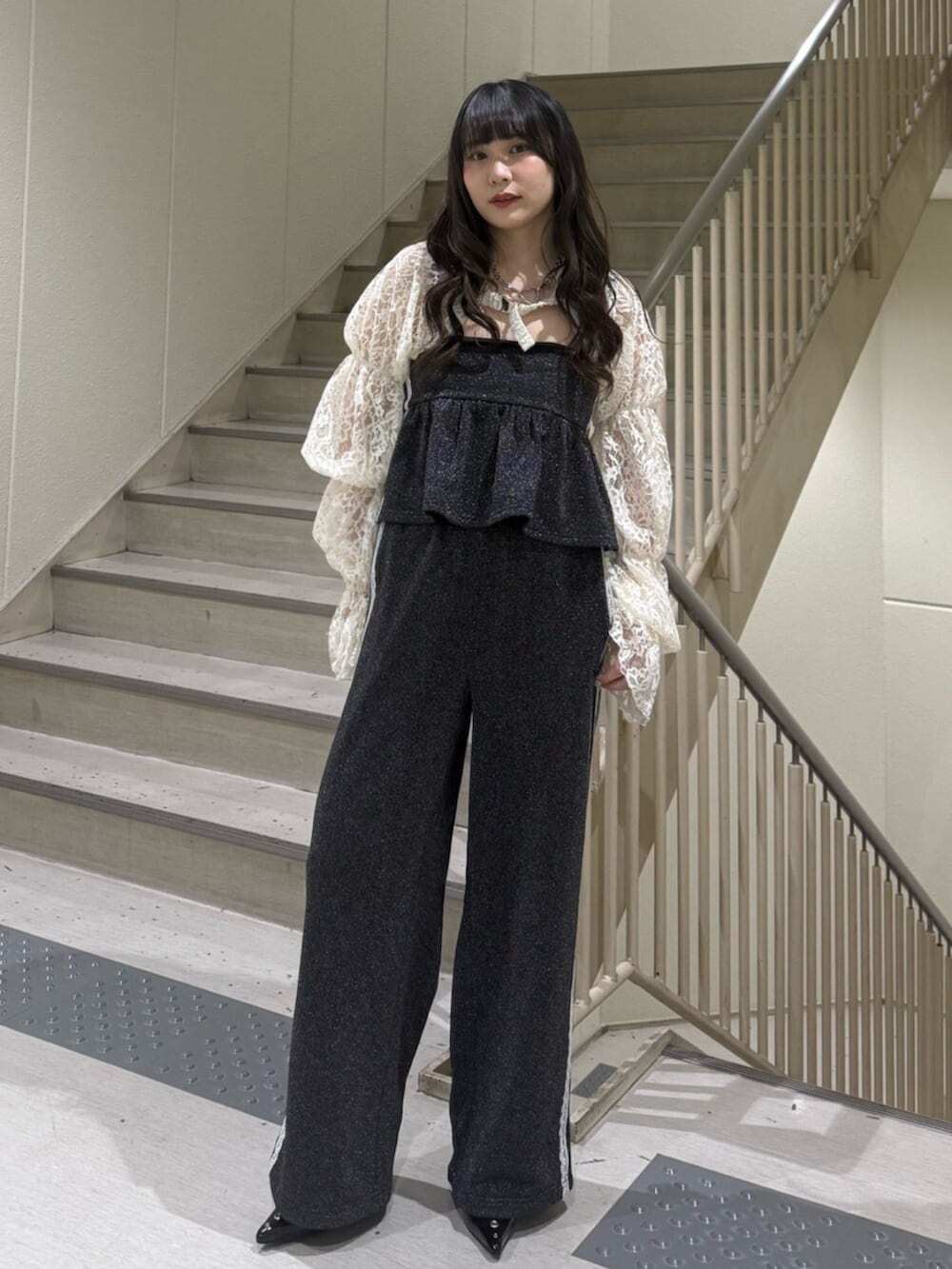 ブラック系のパンプス、ホワイト系のカーディガン/ボレロ、ブラック系のキャミソールを着用したレディースの春コーディネートの2枚目の写真