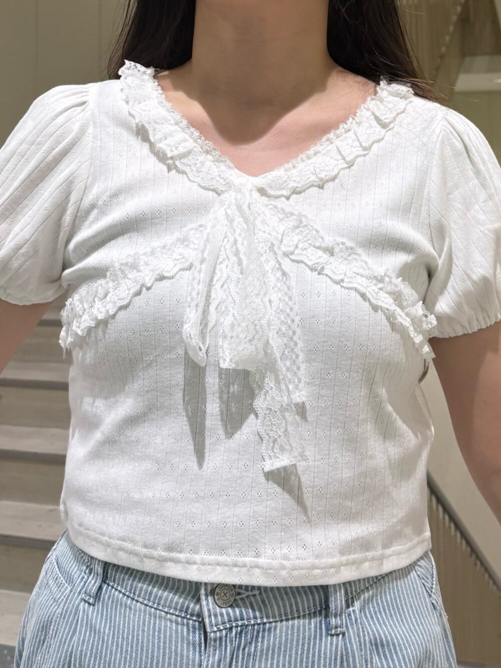 ブラック系のブーツ、ホワイト系のTシャツ/カットソー、ブルー系のデニムパンツを着用したレディースの春コーディネートの6枚目の写真