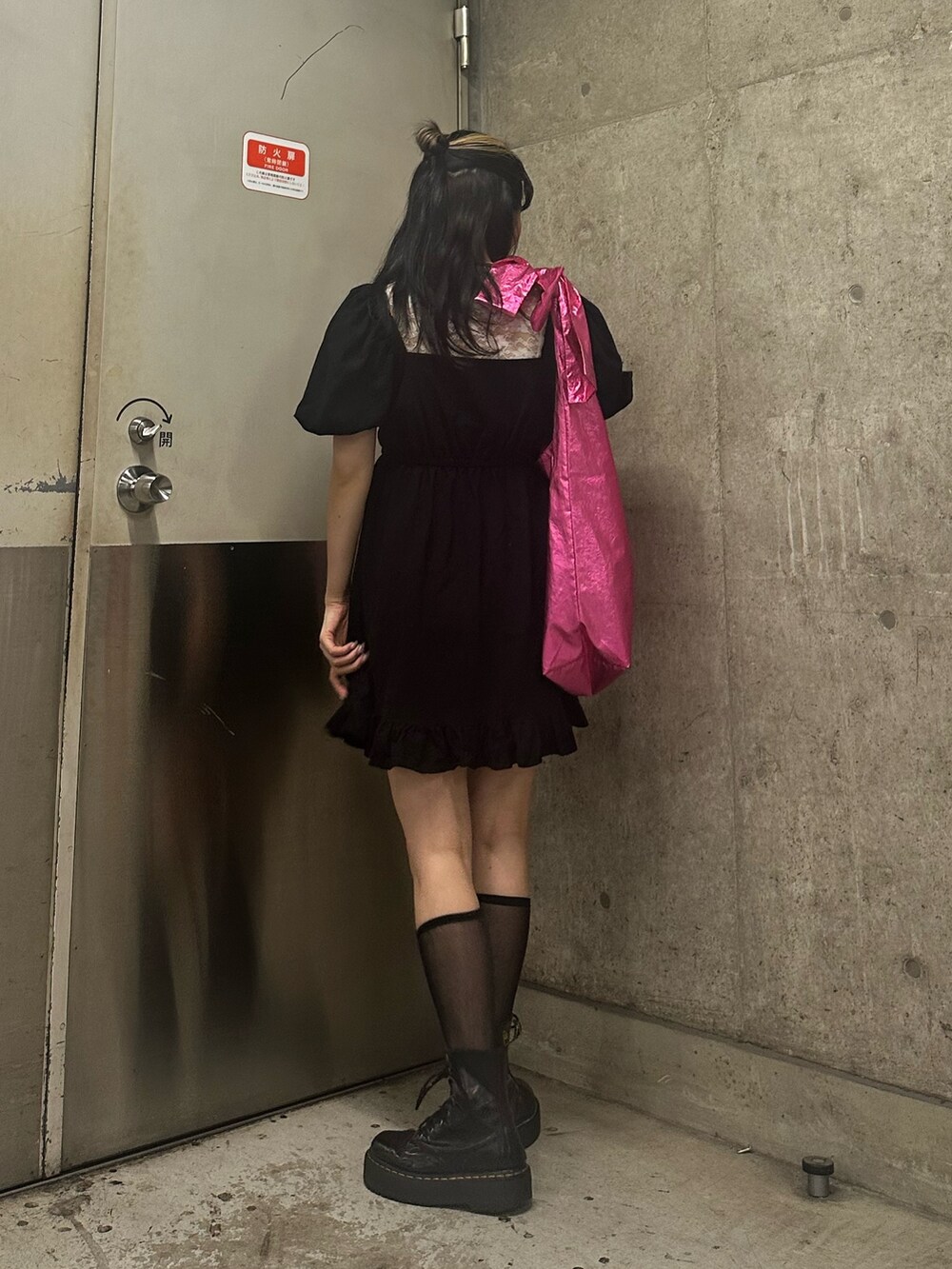 ピンク系のトートバッグ、ブラック系のワンピース、ホワイト系のTシャツ/カットソーを着用したレディースの夏コーディネートの2枚目の写真