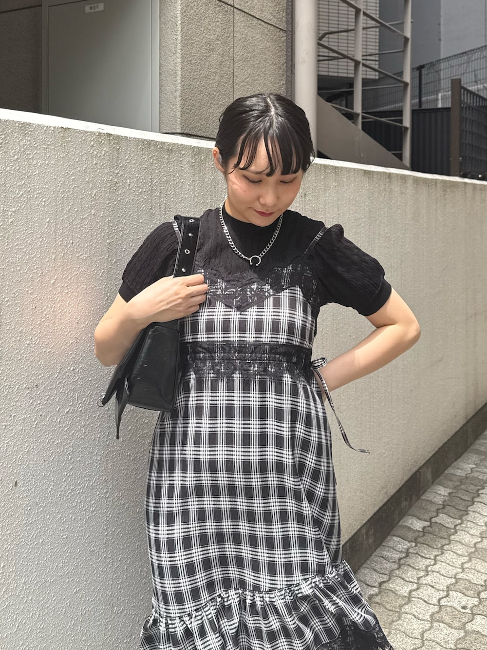 ブラック系のワンピース、ブラック系のニット/セーター、ブラック系のパンプスを着用したレディースの夏コーディネートの4枚目の写真