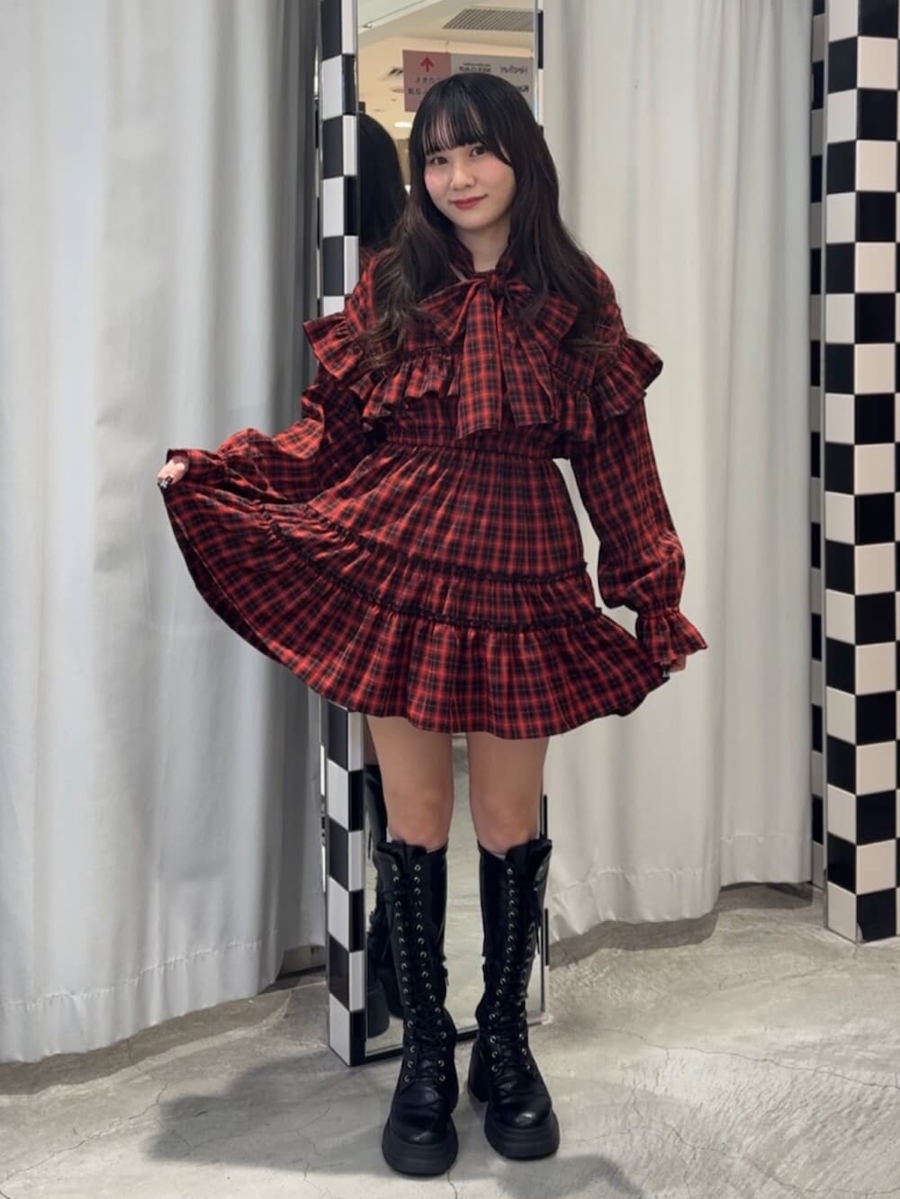 ブラック系のブーツ、レッド系のワンピースを着用したレディースの冬コーディネートの2枚目の写真