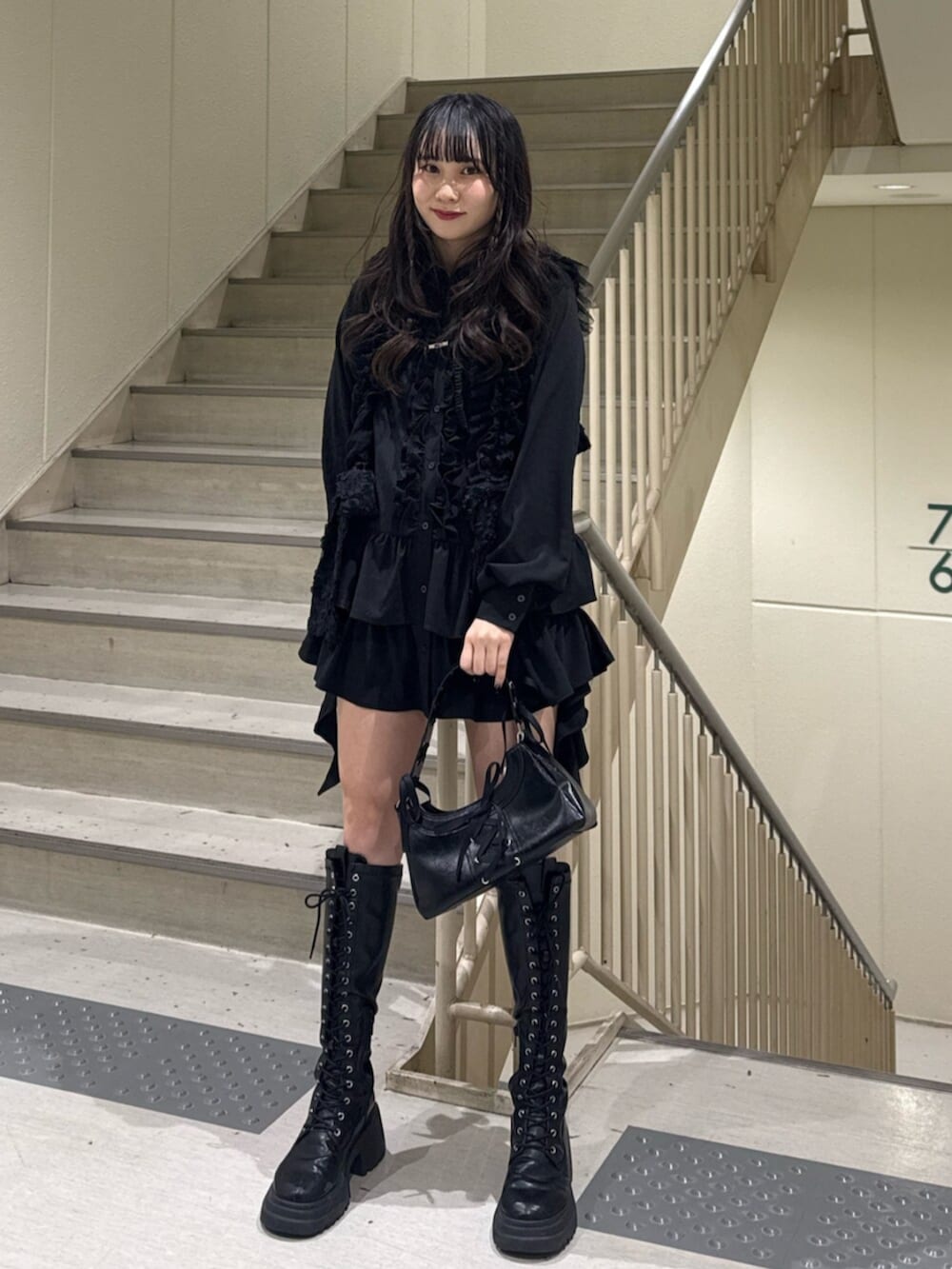 ブラック系のブーツ、ブラック系のハンドバッグ、ブラック系のシャツ/ブラウスを着用したレディースの冬コーディネートの3枚目の写真