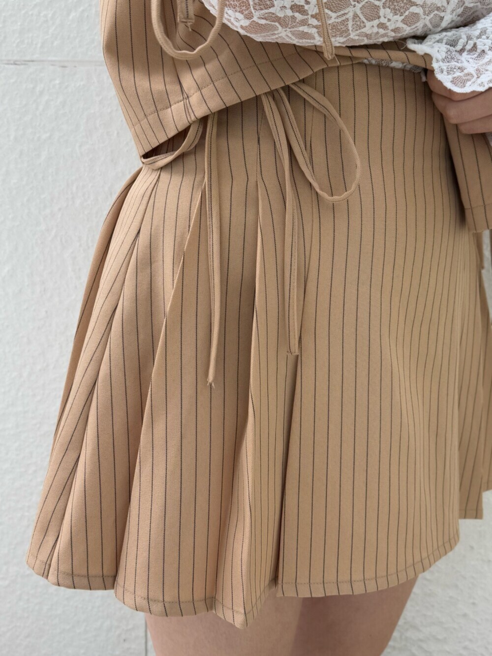 ブラック系のブーツ、ホワイト系のTシャツ/カットソー、ベージュ系のテーラードジャケットを着用したレディースの冬コーディネートの8枚目の写真