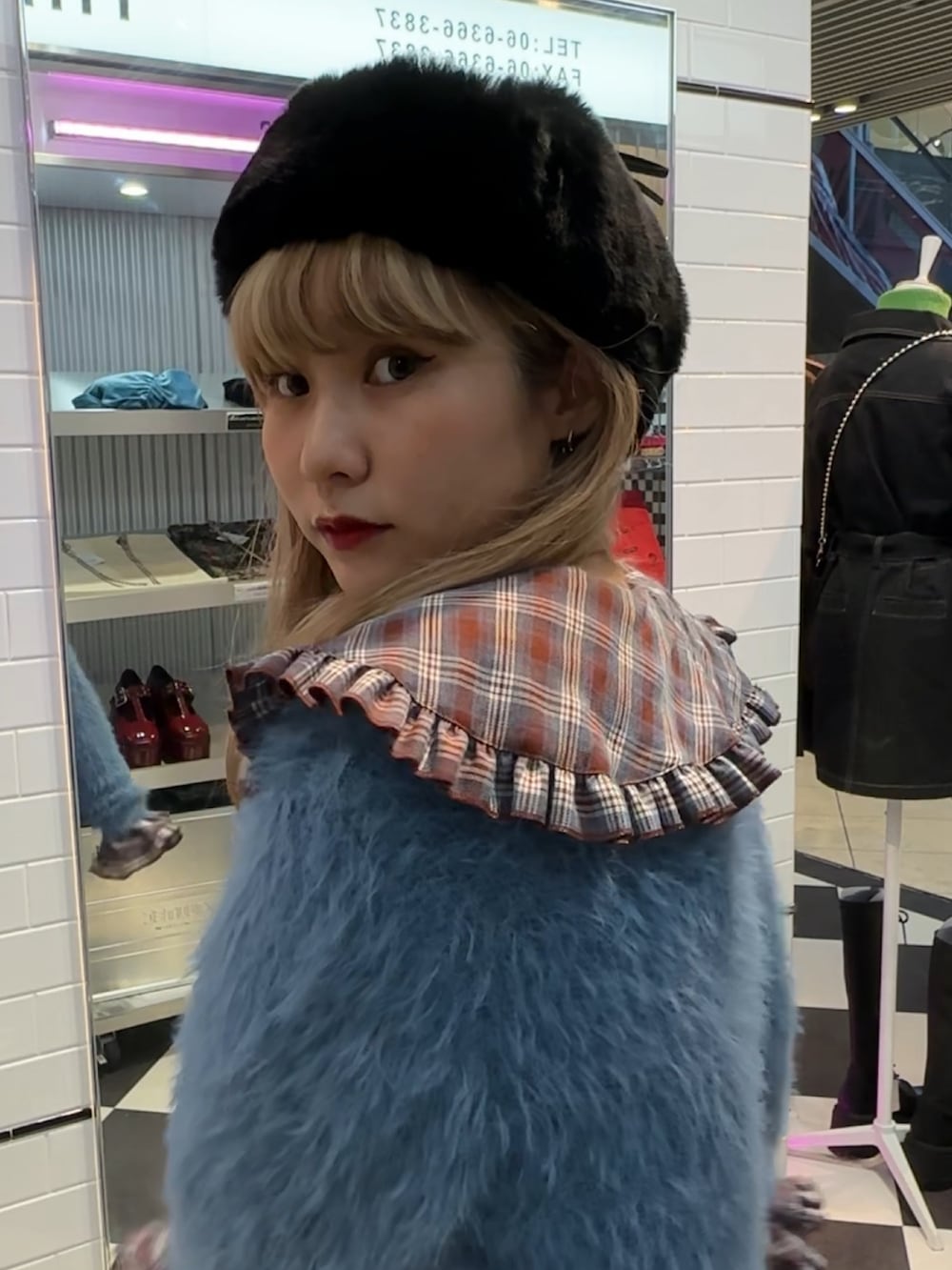 ブラウン系のシャツ/ブラウス、ブルー系のカーディガン/ボレロ、ブラック系のブーツを着用したレディースの秋コーディネートの4枚目の写真