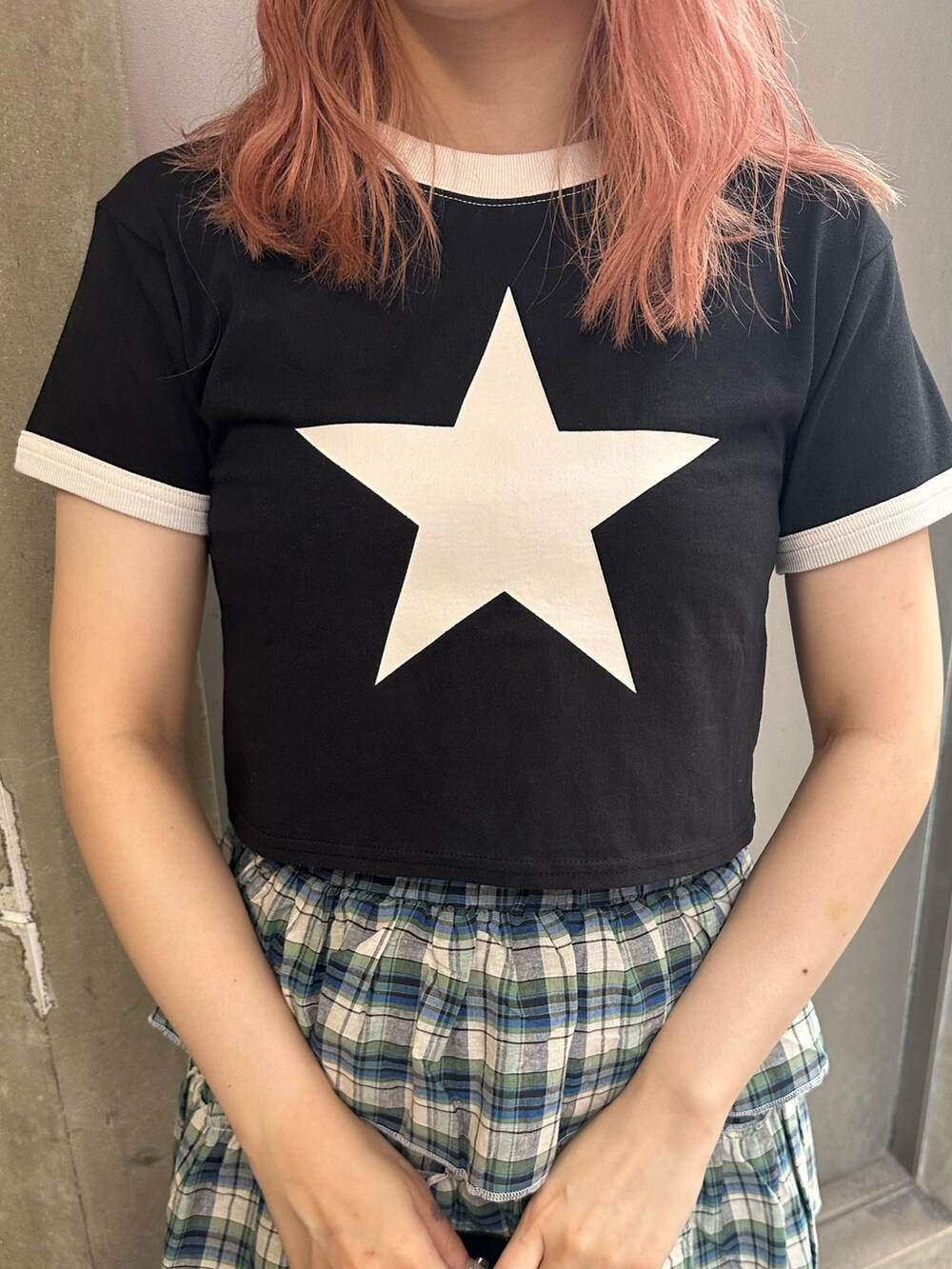 ブラック系のハンドバッグ、ブラック系のTシャツ/カットソー、グリーン系のスカートを着用したレディースの夏コーディネートの6枚目の写真