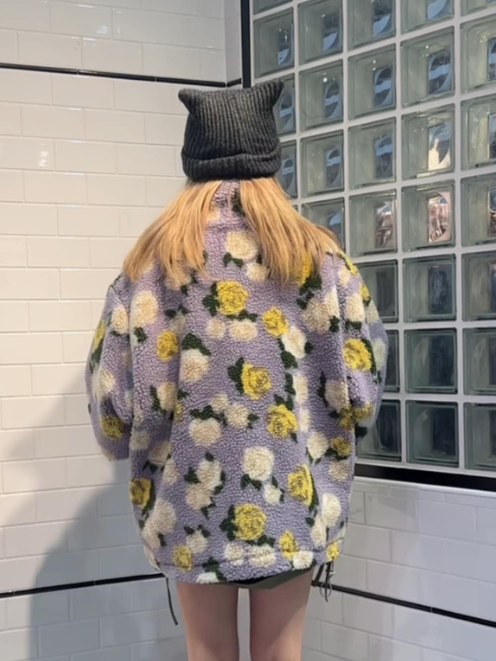 ブラック系のスウェット、パープル系のブルゾン、ブラック系のブーツを着用したレディースの秋コーディネートの3枚目の写真